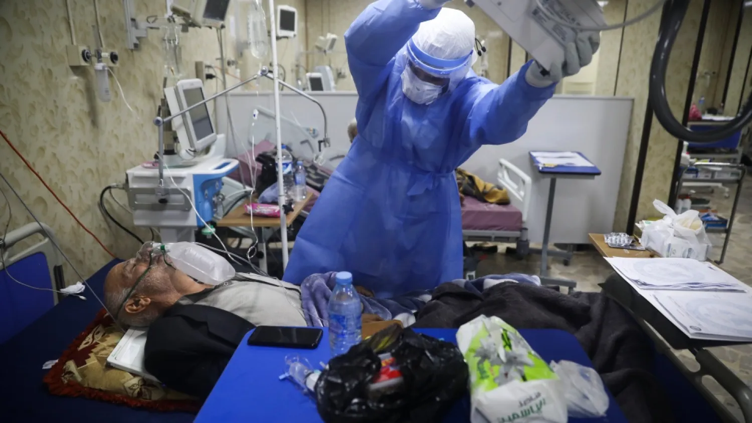 A medic works with corona patients in a hospital in Idlib, Syria, Saturday, Nov. 14, 2020. At one of two coronavirus hospitals in Syria's rebel-held Idlib province, overwhelmed medical staff tend to patients drifting in and out of consciousness. As confirmed case numbers rise to as many as 500 a day, so does the demand for beds in the intensive care ward (AP Photo/Ghaith Alsayed)