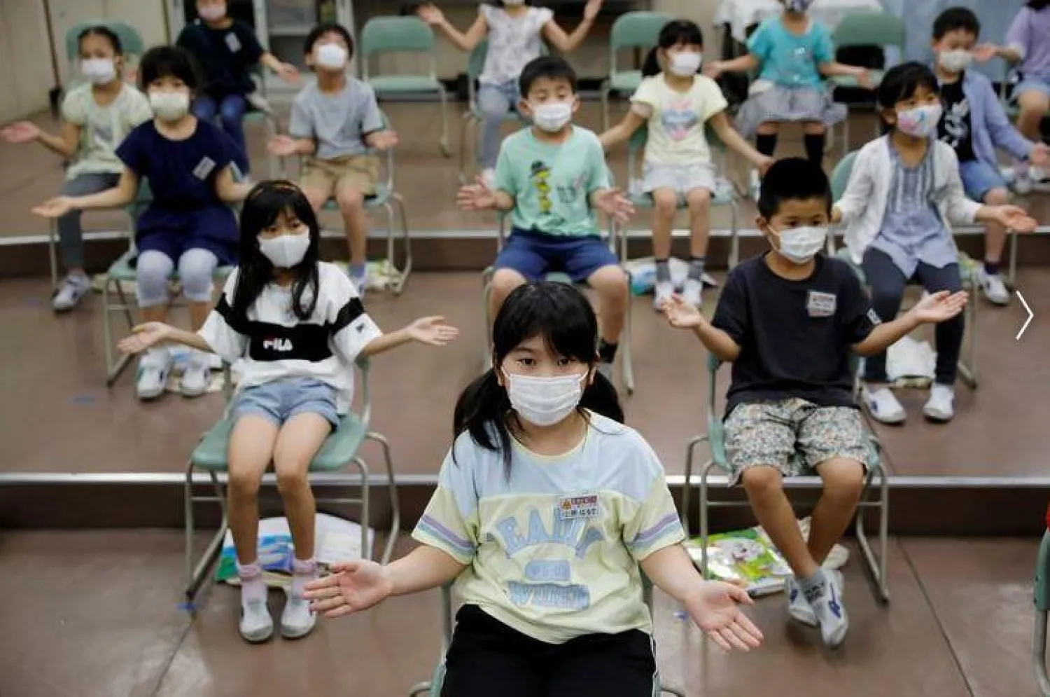 أطفال يرتدون أقنعة واقية للوجه خلال فصل الموسيقى في مدرسة تاكانيداي دايسان شرق طوكيو (أرشفية - رويترز)
