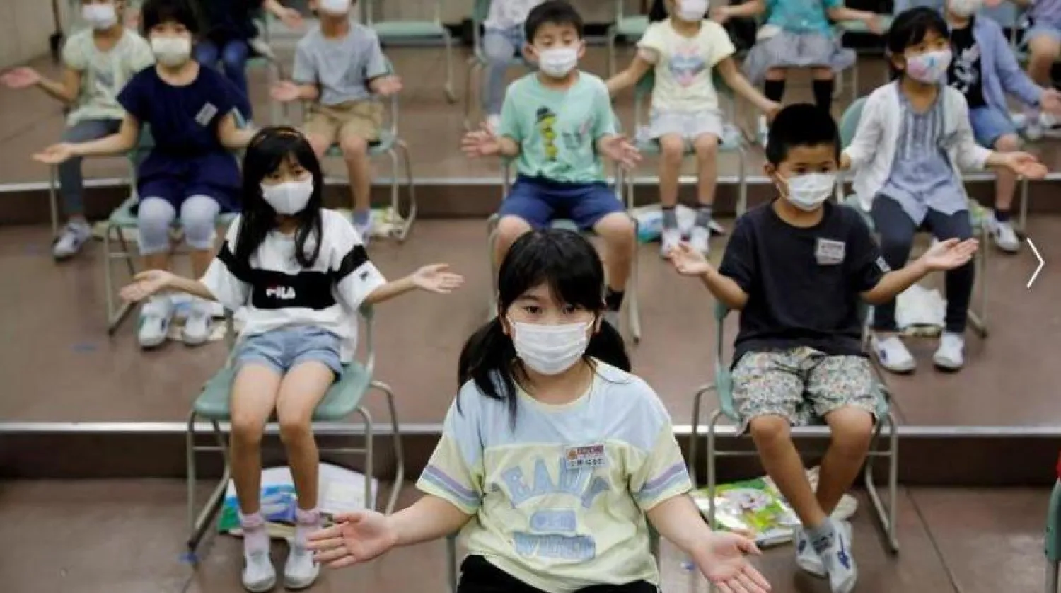 Tokyo’daki bir okulda müzik dersi sırasında maske takan çocuklar (Reuters-Arşiv)