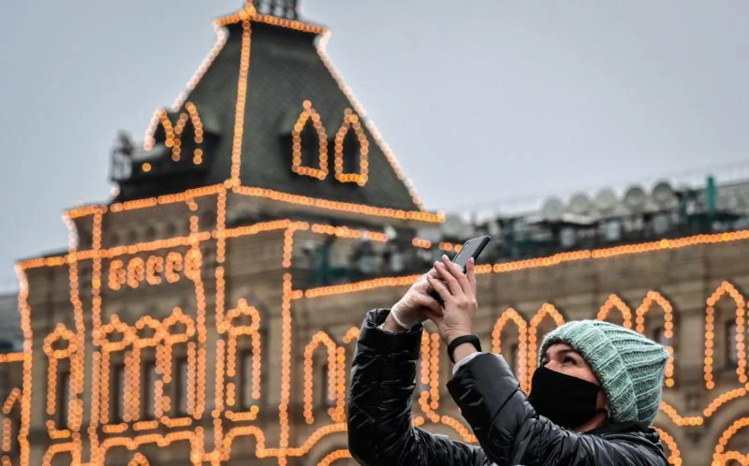 سيدة تستخدم هافها الجوال للتصوير أثناء تجولها في موسكو (أ.ف.ب)