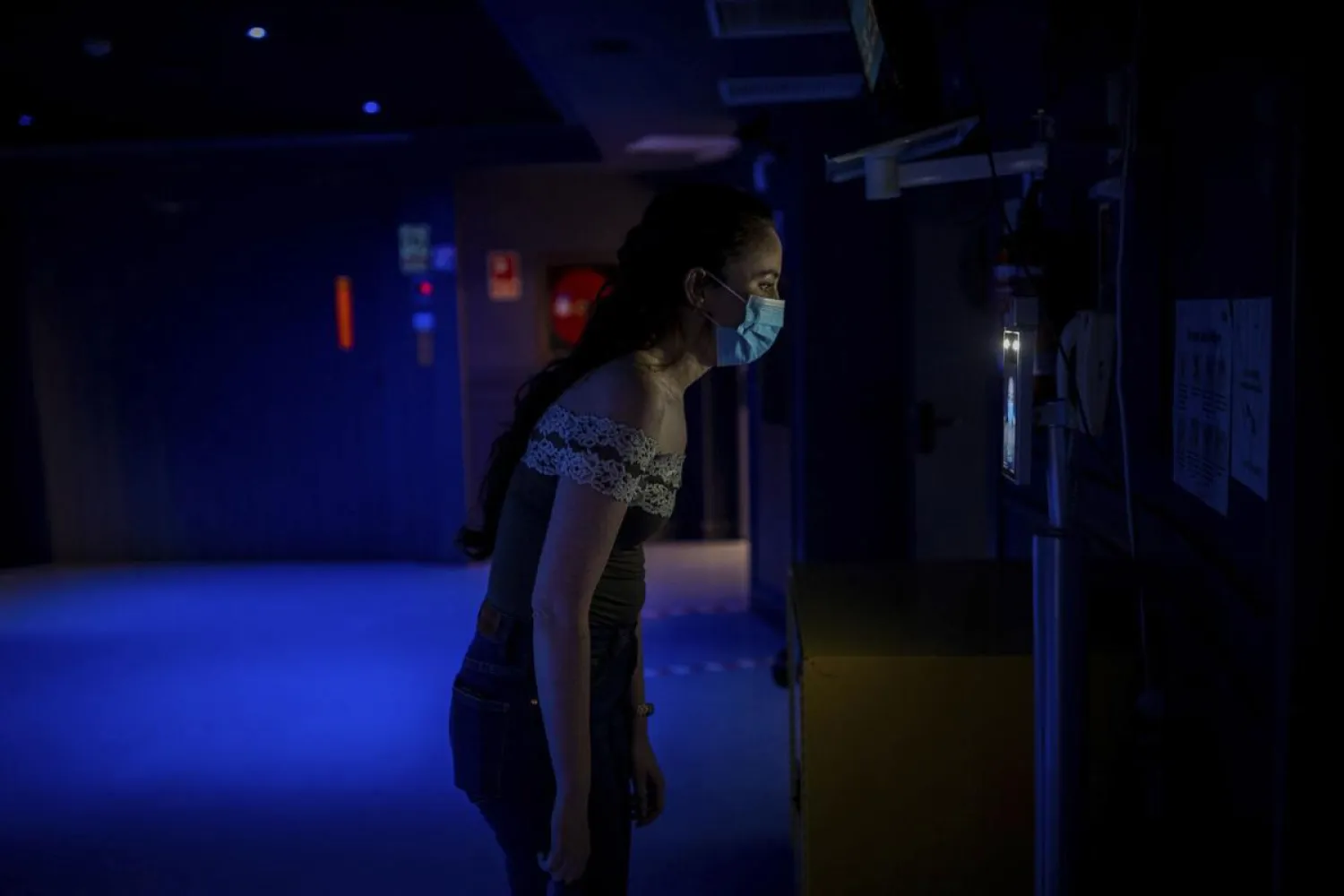A cast member of the opera "Rusalka" gets a temperature check as part of the COVID-19 protocol measures prior to a performance at the Teatro Real in Madrid, Spain, on Friday, Nov. 13, 2020. The theater is one of the few major opera houses that have reopened during the pandemic, although to smaller audiences. (AP Photo/Bernat Armangue)