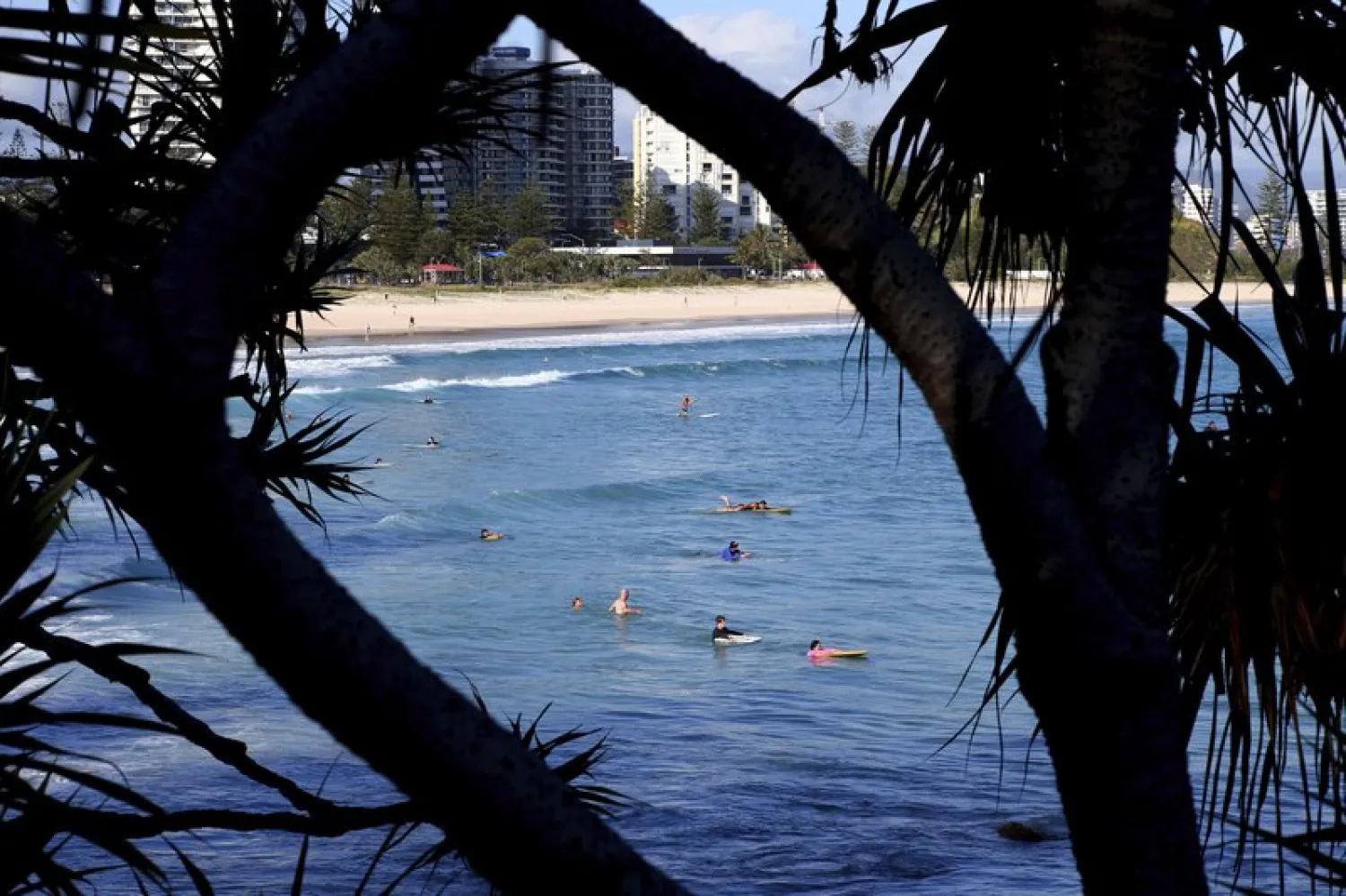 FILE: Surfers wade in the water waiting for waves off the Southern Gold Coast area of Greenmount Beach, Gold Coast, Friday, Dec. 15, 2017. A shark fatally mauled a man on Tuesday on Australia’s Gold Coast city tourist strip, an official said. (David Clark/AAP via AP)
