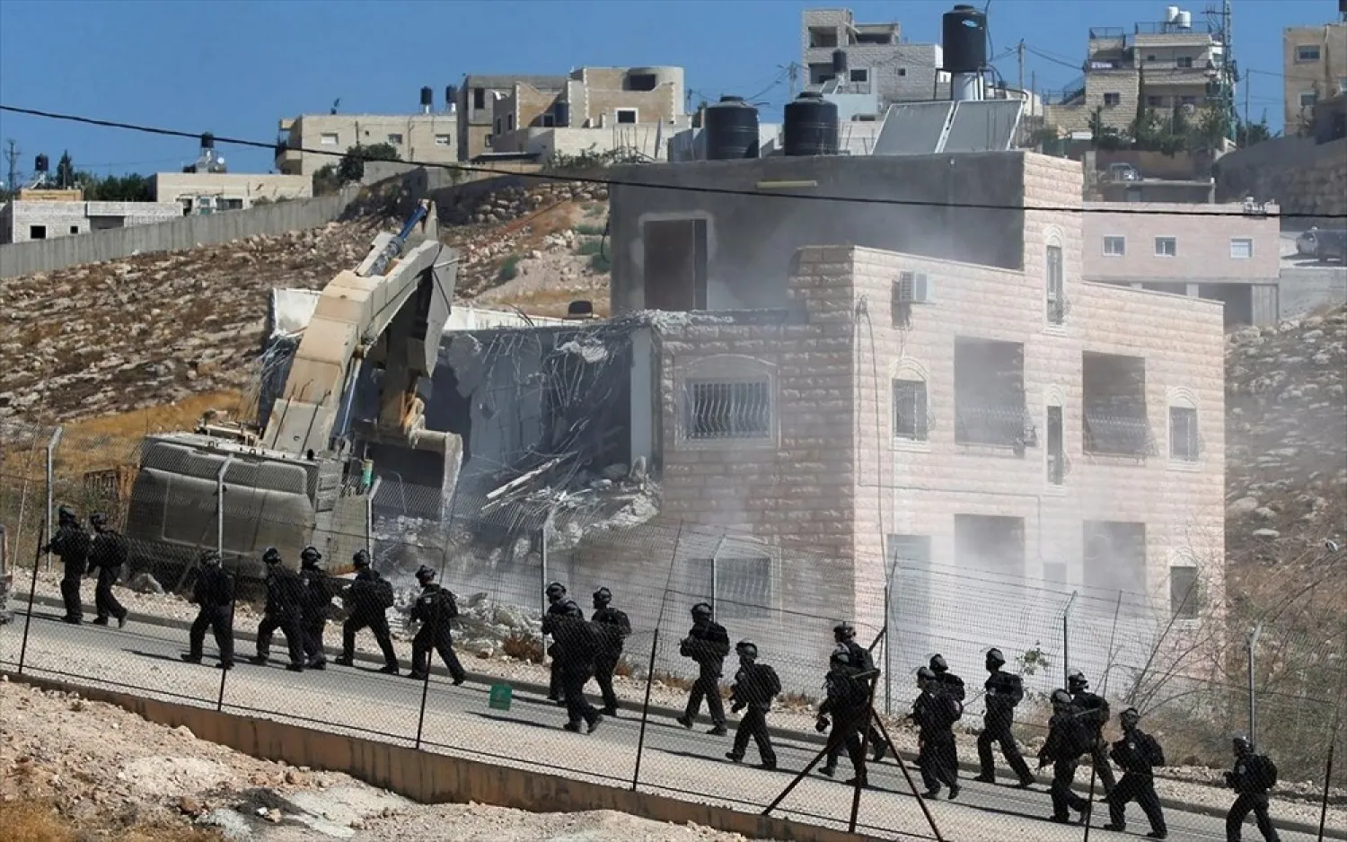 Israeli forces patrol as machinery demolishes a Palestinian building in the village of Sur Baher which is divided by the Israeli barrier in east Jerusalem and the West Bank on July 22, 2019. (Reuters)