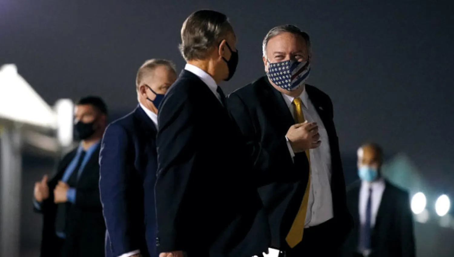 بومبيو يتحدث إلى السفير الأميركي لدى الإمارات جون راكولتا قبل مغادرة أبوظبي أمس (أ.ب)