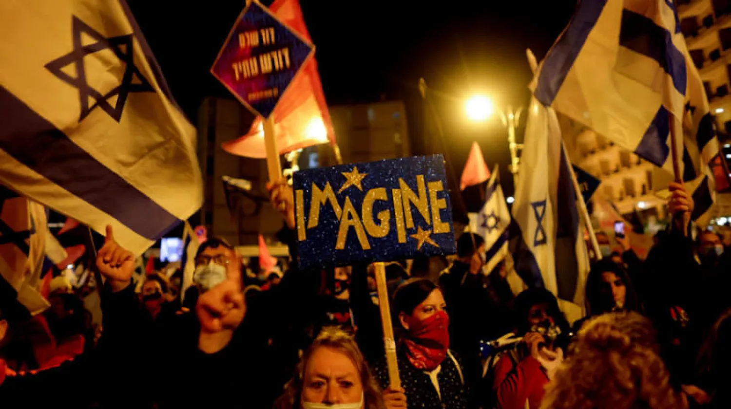 احتجاجات ضد تعامل نتنياهو مع جائحة كورونا ليلة السبت في القدس (رويترز)