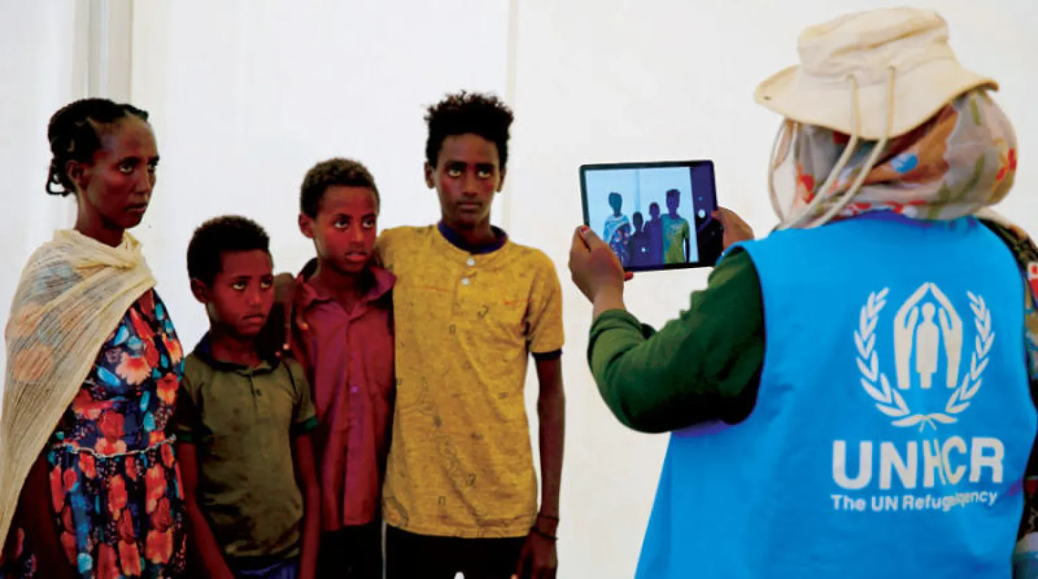 موظفة من مفوضية اللاجئين تسجل بعض الفارين من حرب إثيوبيا (رويترز)