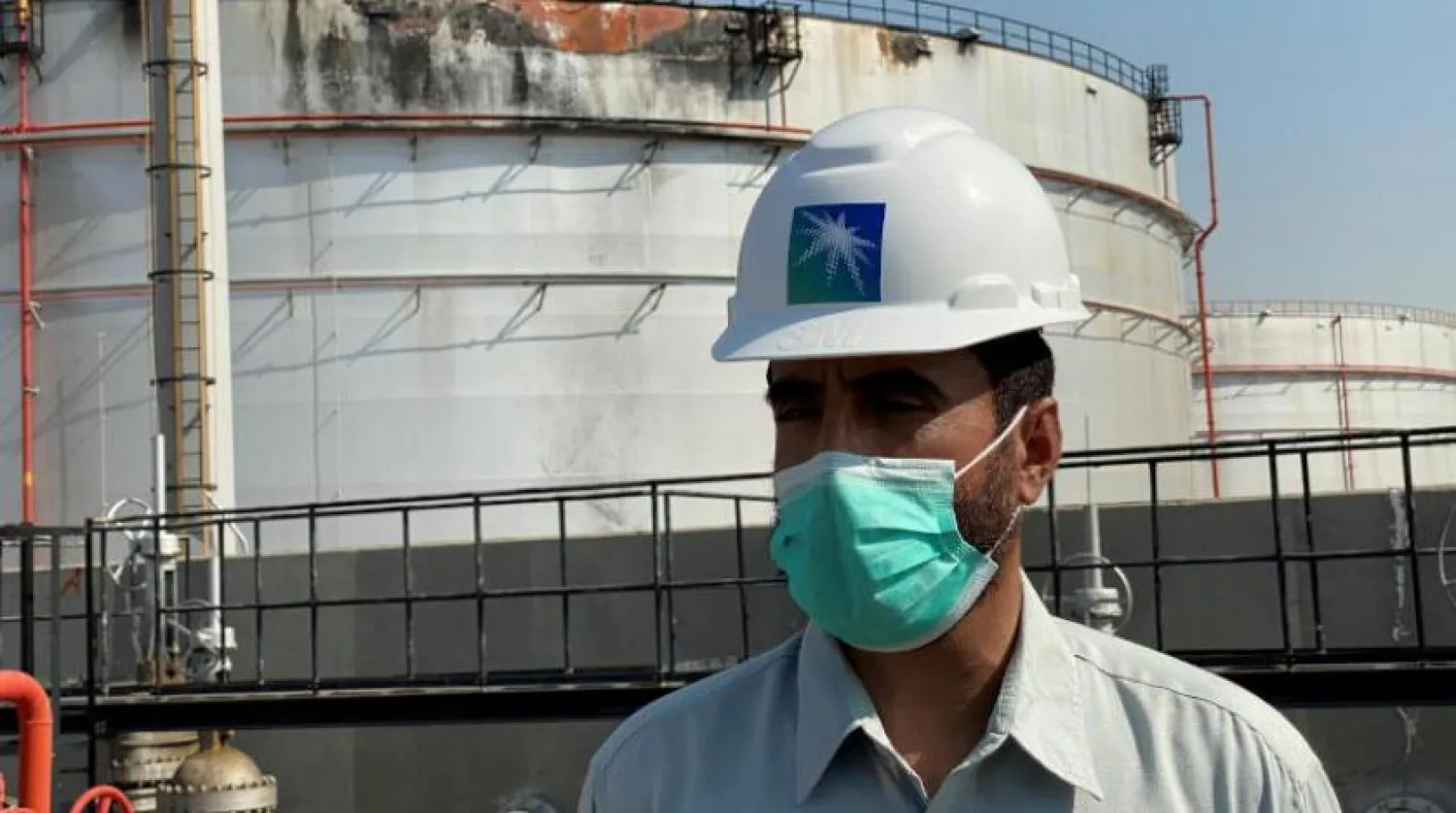 Aramco çalışanı, Cidde şehrindeki dağıtım istasyonunda hasar gören tankın önünde duruyor (Reuters)