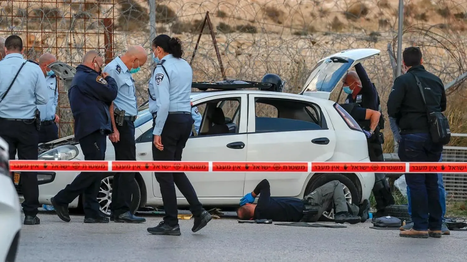 Israeli security forces inspect the scene where Israeli border police shot at a Palestinian driver who allegedly tried to ram them at Al-Zaim checkpoint on the outskirts of east Jerusalem. (AFP)