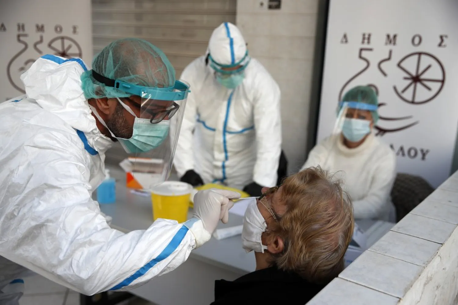 Medical staff conducts a rapid COVID test on an elderly woman in Athens, Monday, Nov. 23, 2020. Greece has seen a major resurgence of the virus after the summer, leading to dozens of deaths each day and thousands of new infections. (AP Photo/Thanassis Stavrakis)
