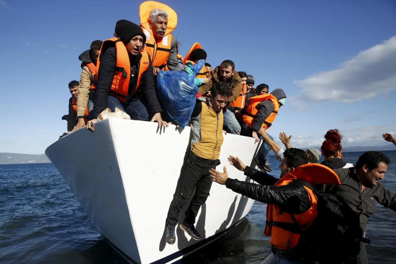 Refugees and migrants jump off a boat as they arrive on the Greek island of Lesbos, November 26, 2015. REUTERS/Giorgos Moutafis