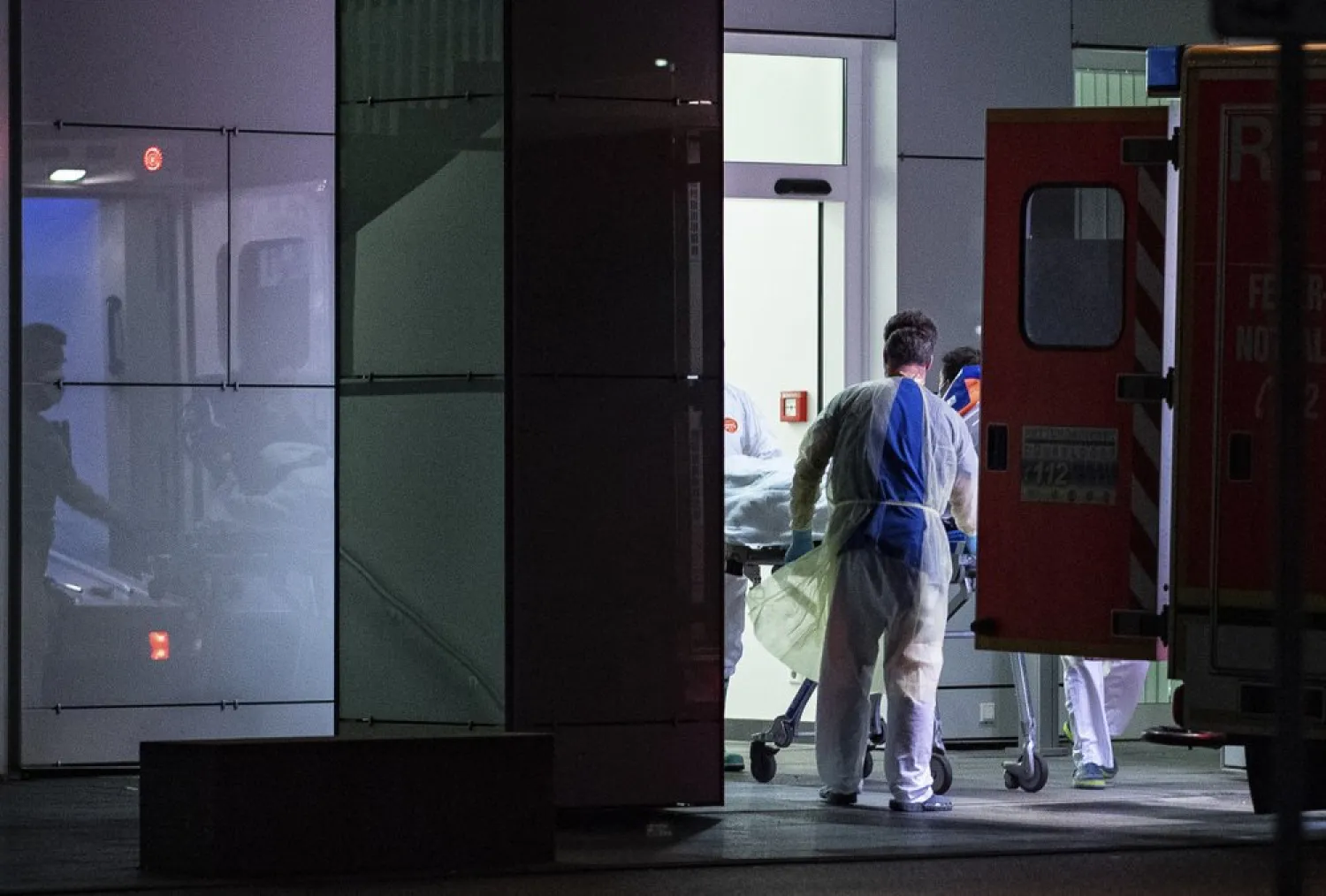 Medical staff in carry the first person infected with the coronavirus in the German state of North Rhine Westphalia out of an ambulance into the Liver and Infection Center of the University Hospital in Duesseldorf, Germany, Wednesday, Feb 26, 2020. (Guido Kirchner/dpa via AP)
