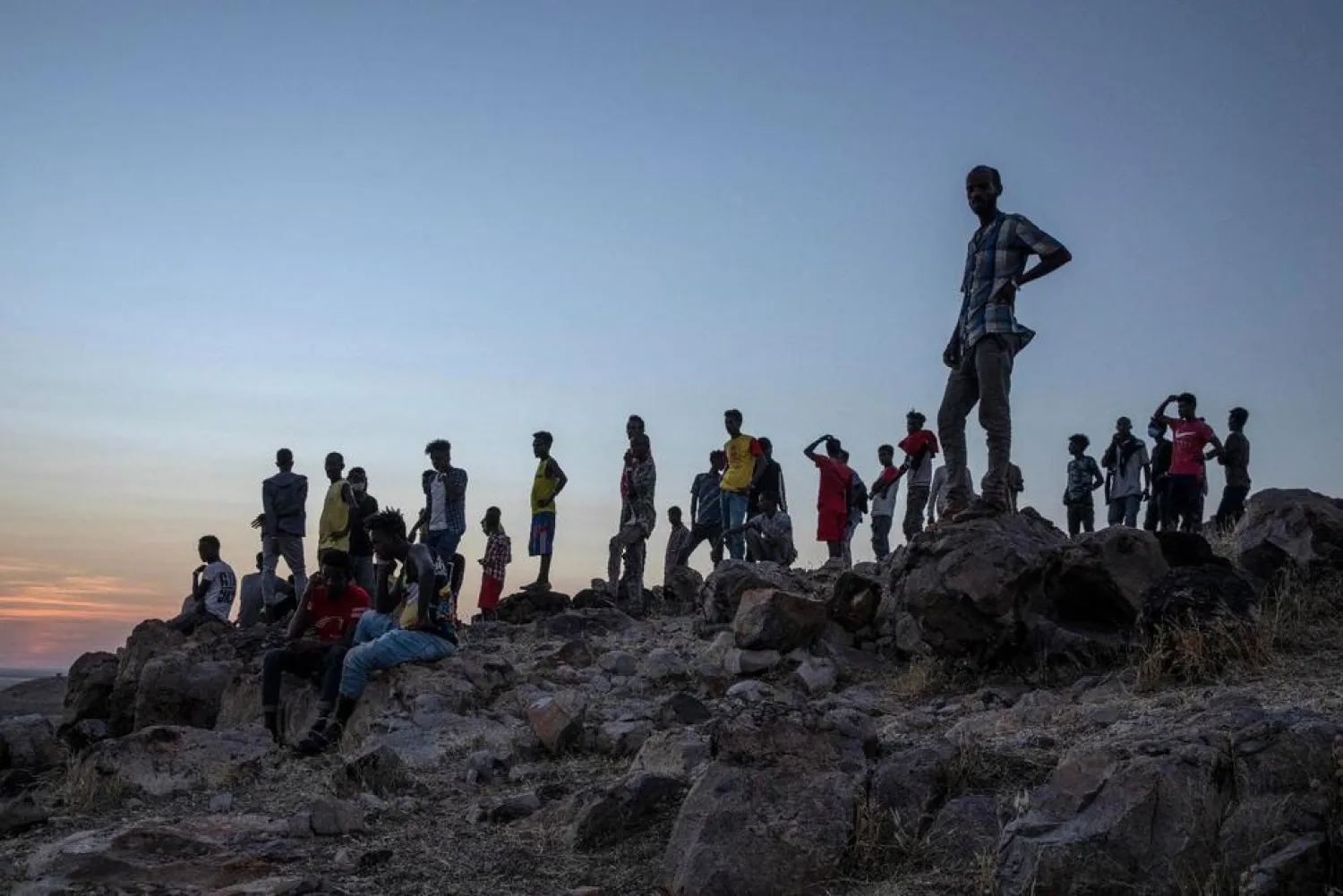 Tigray people who fled the conflict in Ethiopia's Tigray region, stand on a hill top over looking Umm Rakouba refugee camp in Qadarif, eastern Sudan, Thursday, Nov. 26, 2020. (AP Photo/Nariman El-Mofty)

