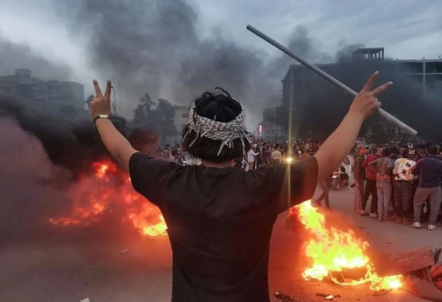 An Iraqi demonstrator stands near burning tires during clashes between anti-government protesters and supporters of firebrand Shiite cleric Moqtada Sadr in the southern city of Nasiriyah on Friday. AFP