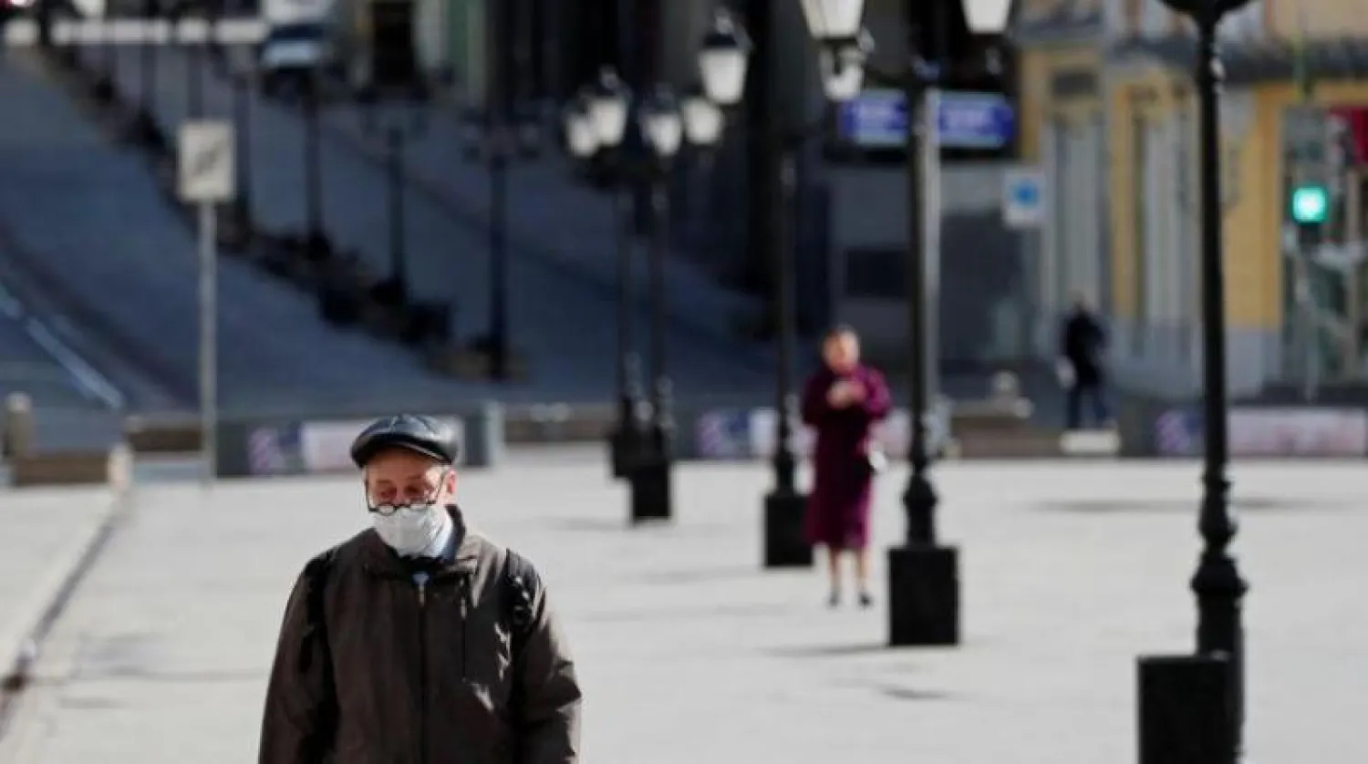 رجل يسير في أحد ميادين موسكو مرتدياً كمامة للوقاية من «كورونا» (أرشيفية - رويترز)