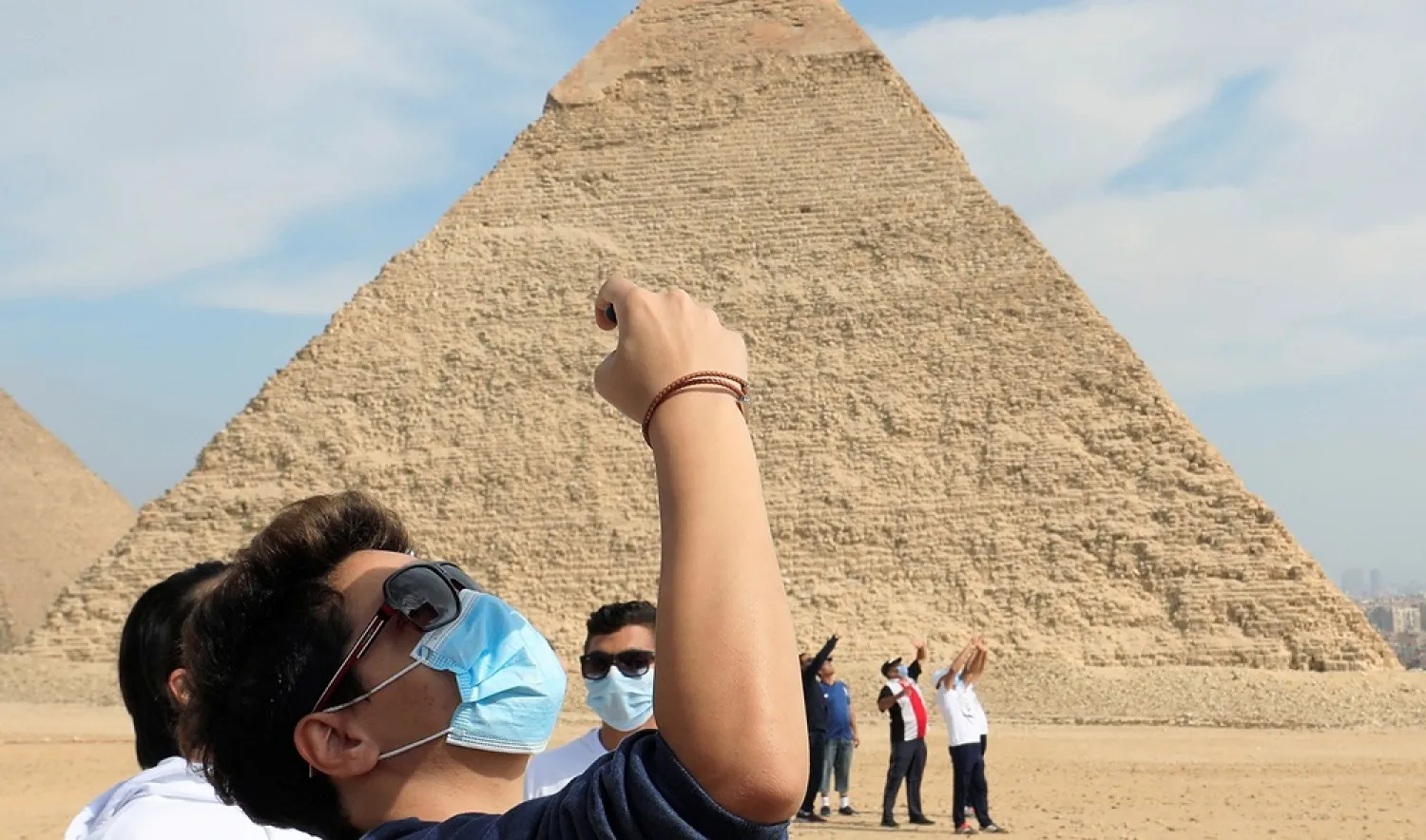Tourists wearing protective face masks are seen in front of the pyramid of Khafre in Giza, Egypt, November 9, 2020. (Reuters)