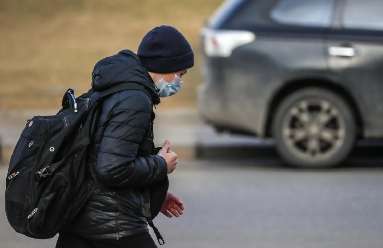 رجل يرتدي قناعاً واقياً ويسير في أحد شوارع موسكو (إ.ب.أ)