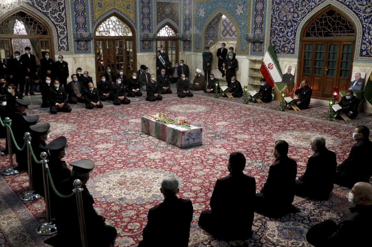 In this picture released by Iran's Defense Ministry and taken on Nov. 28, 2020, people pray over the coffin of Mohsen Fakhrizadeh during a funeral in Mashhad, Iran. (AP)