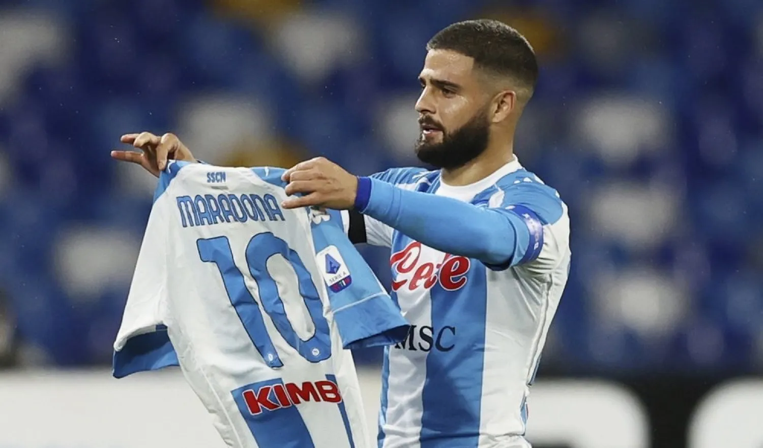 Lorenzo Insigne of Napoli holding a number 10 Maradona shirt, celebrates after scoring the first goal of the game against AS Roma, in Naples, Italy, Sunday, Nov. 29, 2020. (AP)