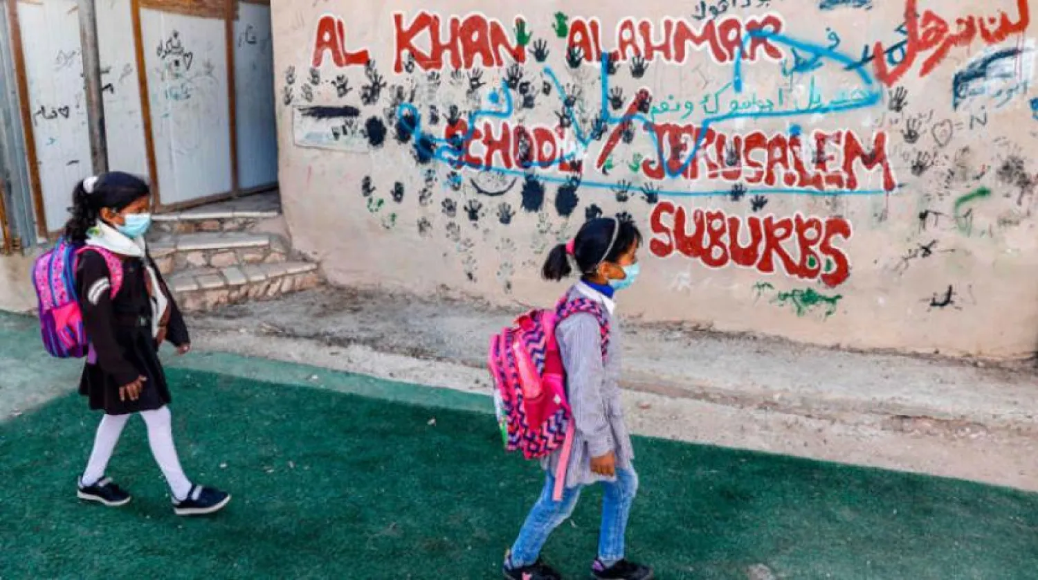 İki Filistinli kız çocuğu Batı Şeria’da bulunan Han el-Ahmer’de okullarına gidiyor (AFP)