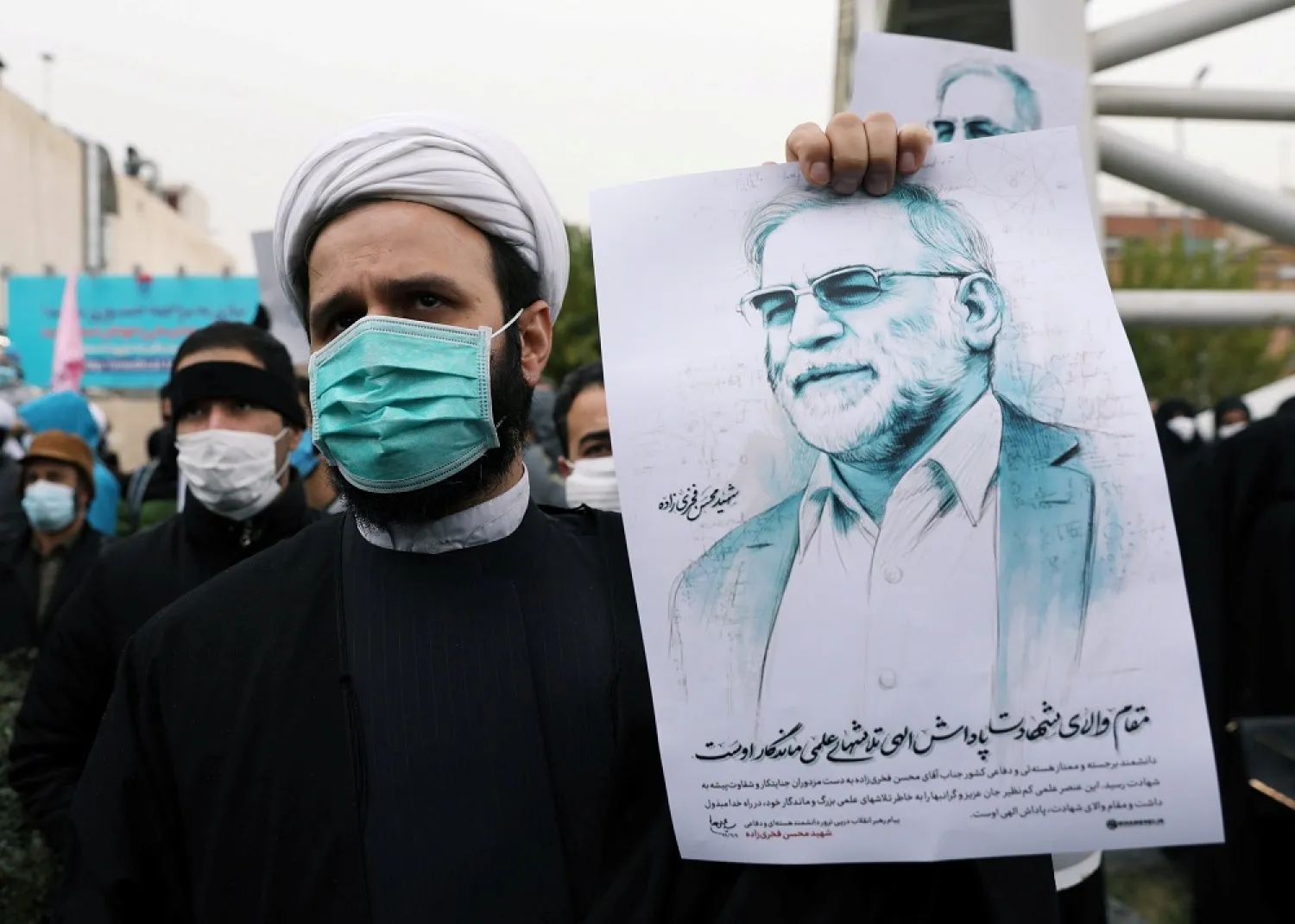 A protester holds a picture of Mohsen Fakhrizadeh during a rally against his killing in Tehran, Iran, Nov. 28, 2020. (Reuters)