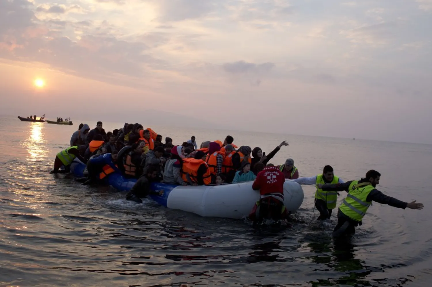 FILE -  Volunteers help migrants and refugees on a dingy as they arrive at the shore of the northeastern Greek island of Lesbos, after crossing the Aegean sea from Turkey. (AP Photo/Petros Giannakouris)
