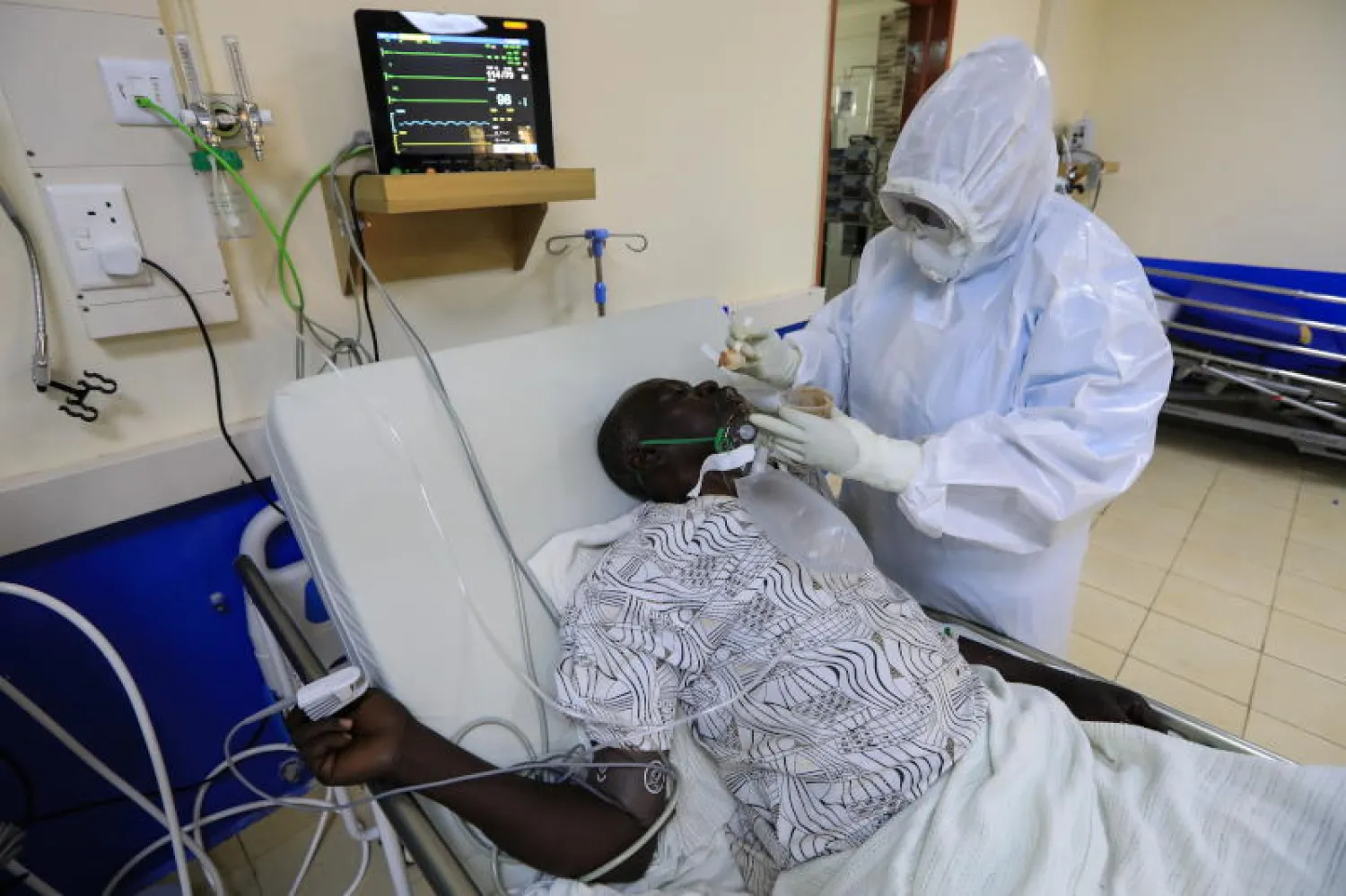 ممرض يقوم بإطعام مريض مصاب بـ«كورونا» في مستشفى بكينيا (إ.ب.أ)