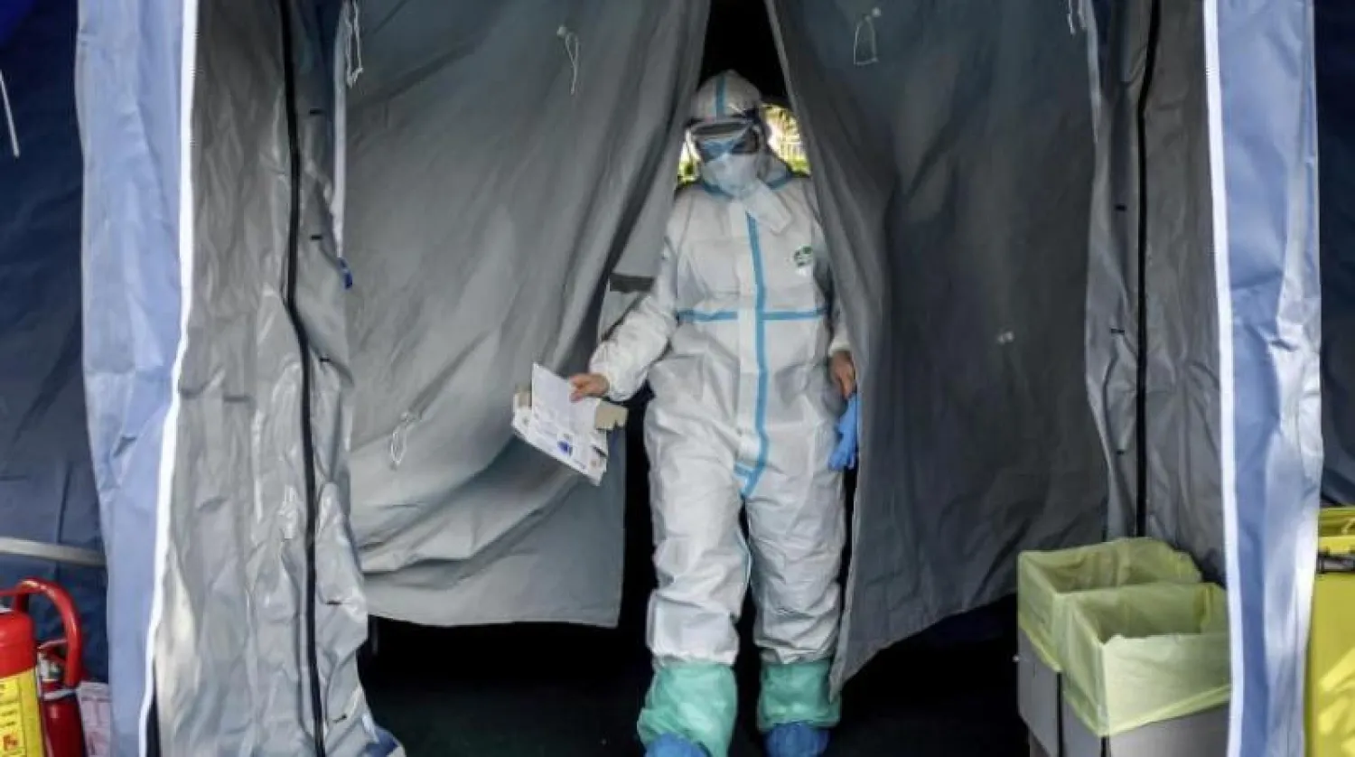 عضو في فريق طبي يغادر خيمة الطوارئ التي خارج مستشفى في بريشيا بشمال إيطاليا (أ.ب)