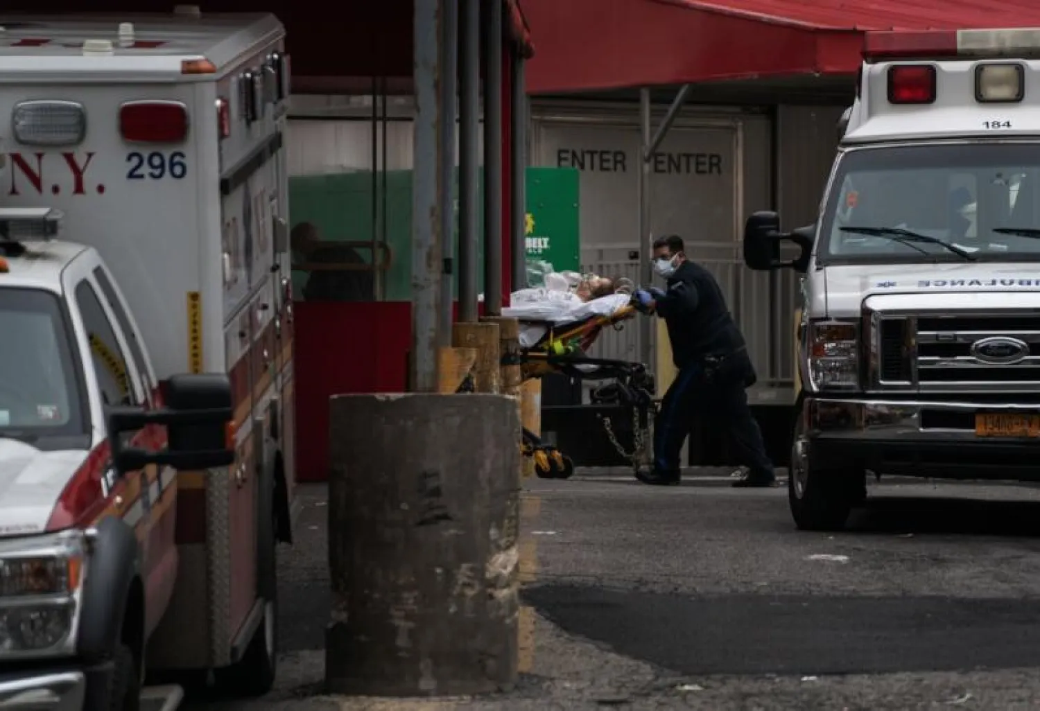 أحد أفراد الطاقم الطبي بمستشفي ماونت سيناي بحي كوينز ينقل أحد مصابي «كورونا» من ذوي الحالات الحرجة (نيويورك تايمز)