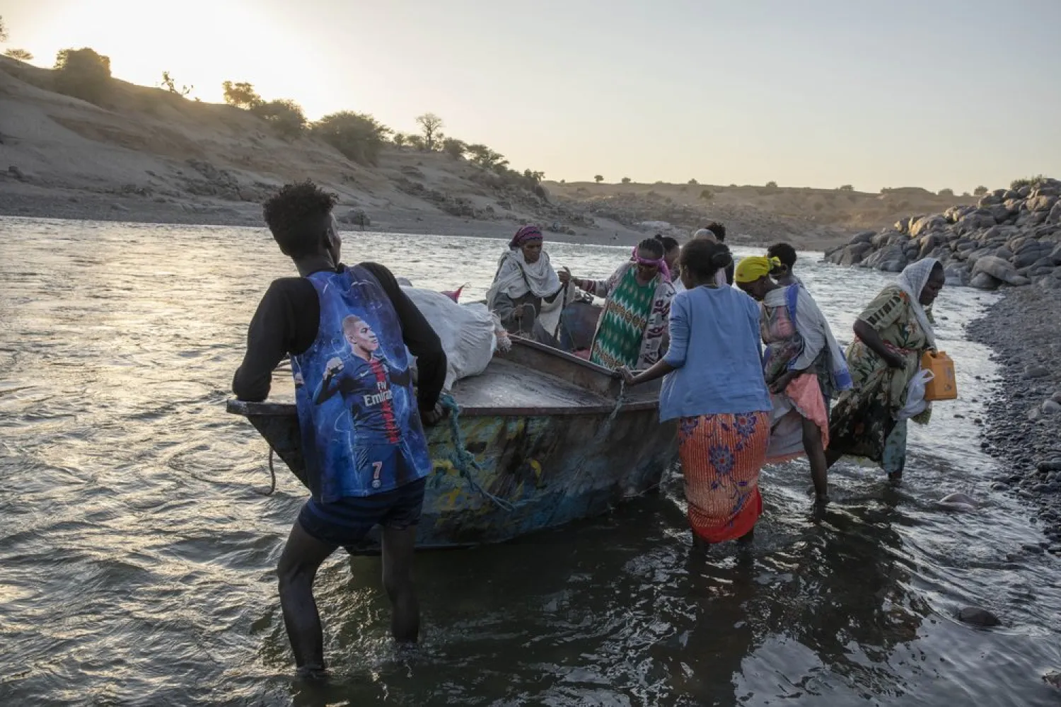 Tigray refugees arrive on the banks of the Tekeze River on the Sudan-Ethiopia border, in Hamdayet, eastern Sudan, Wednesday, Dec. 2, 2020. Ethiopian forces on Thursday, Dec. 3, 2020 blocked people from the country's embattled Tigray region from crossing into Sudan at the busiest crossing point for refugees, Sudanese forces said. (AP Photo/Nariman El-Mofty)
