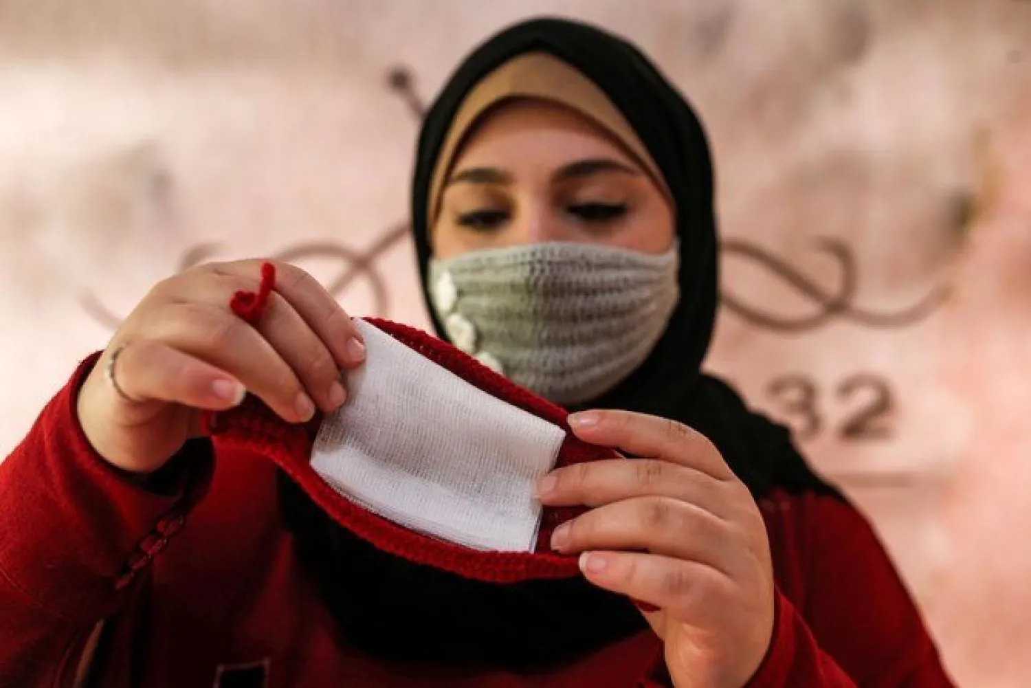 Nouran Faraj, a 24-year-old Palestinian, creates a handmade crochet wool masks (prevention measure for the COVID-19 coronavirus pandemic) in Gaza City on December 1, 2020. (AFP)

