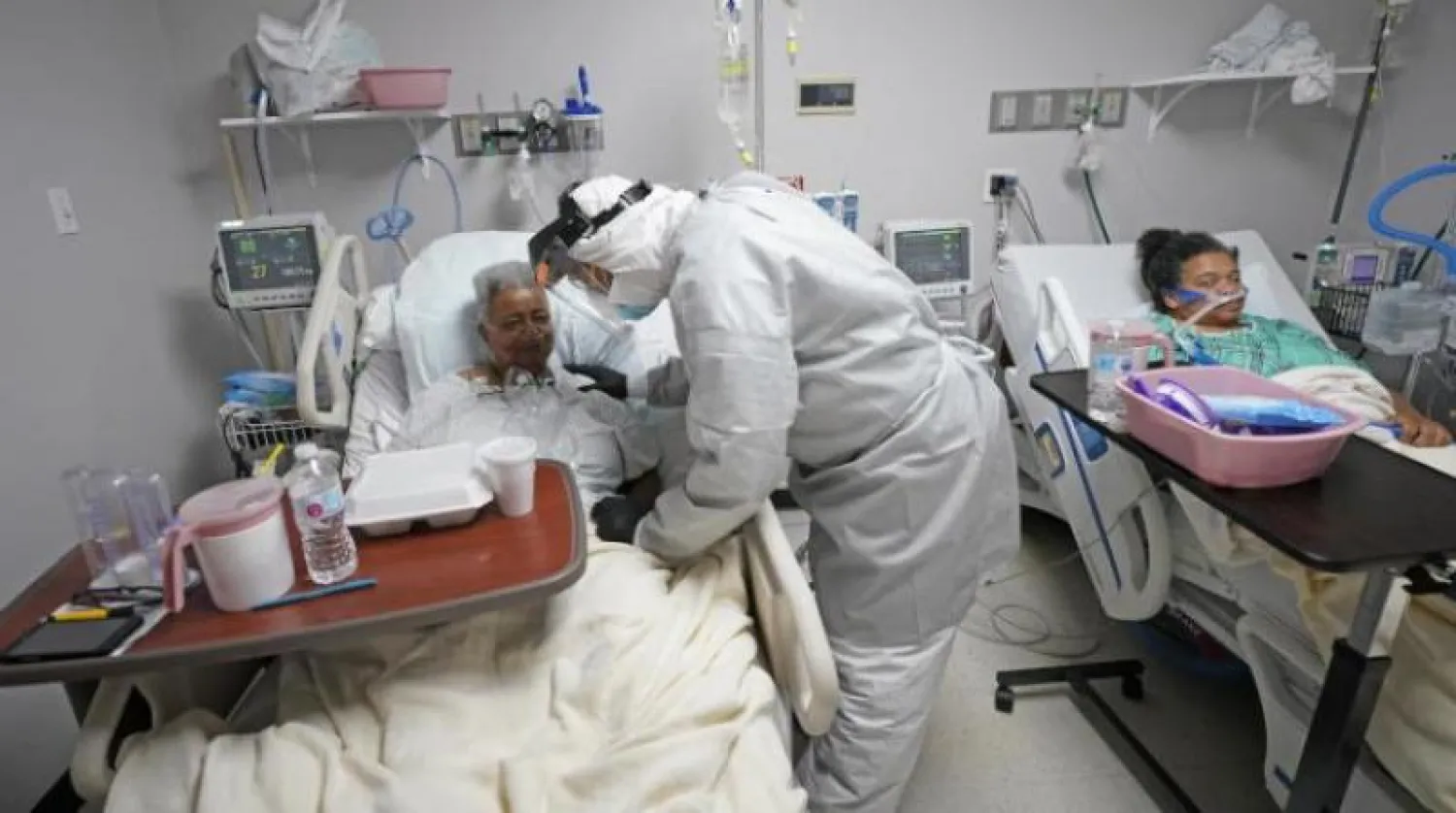 طبيب يتفقد مريضتين مصابتين بـ«كورونا» في أحد مستشفيات تكساس بالولايات المتحدة (أ.ب)