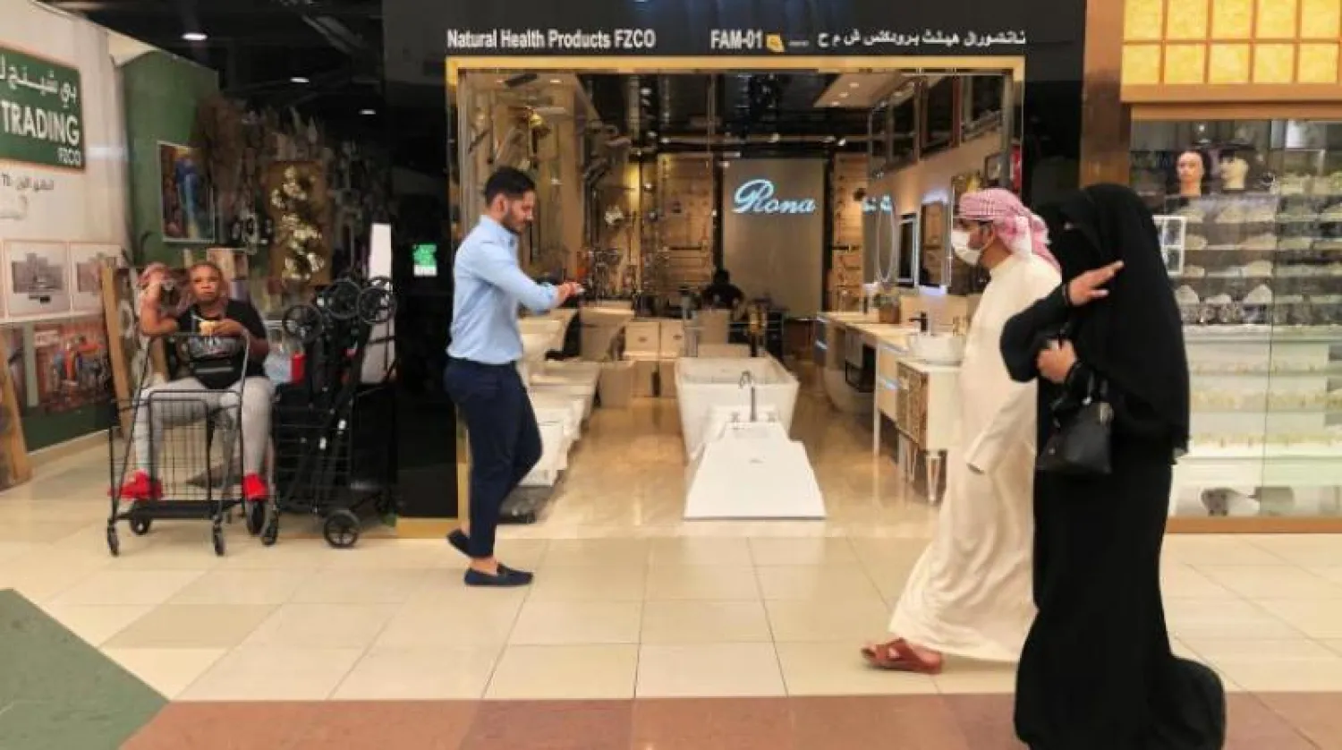 رجل يرتدي قناعاً واقياً في إحدى أسواق دبي (رويترز)