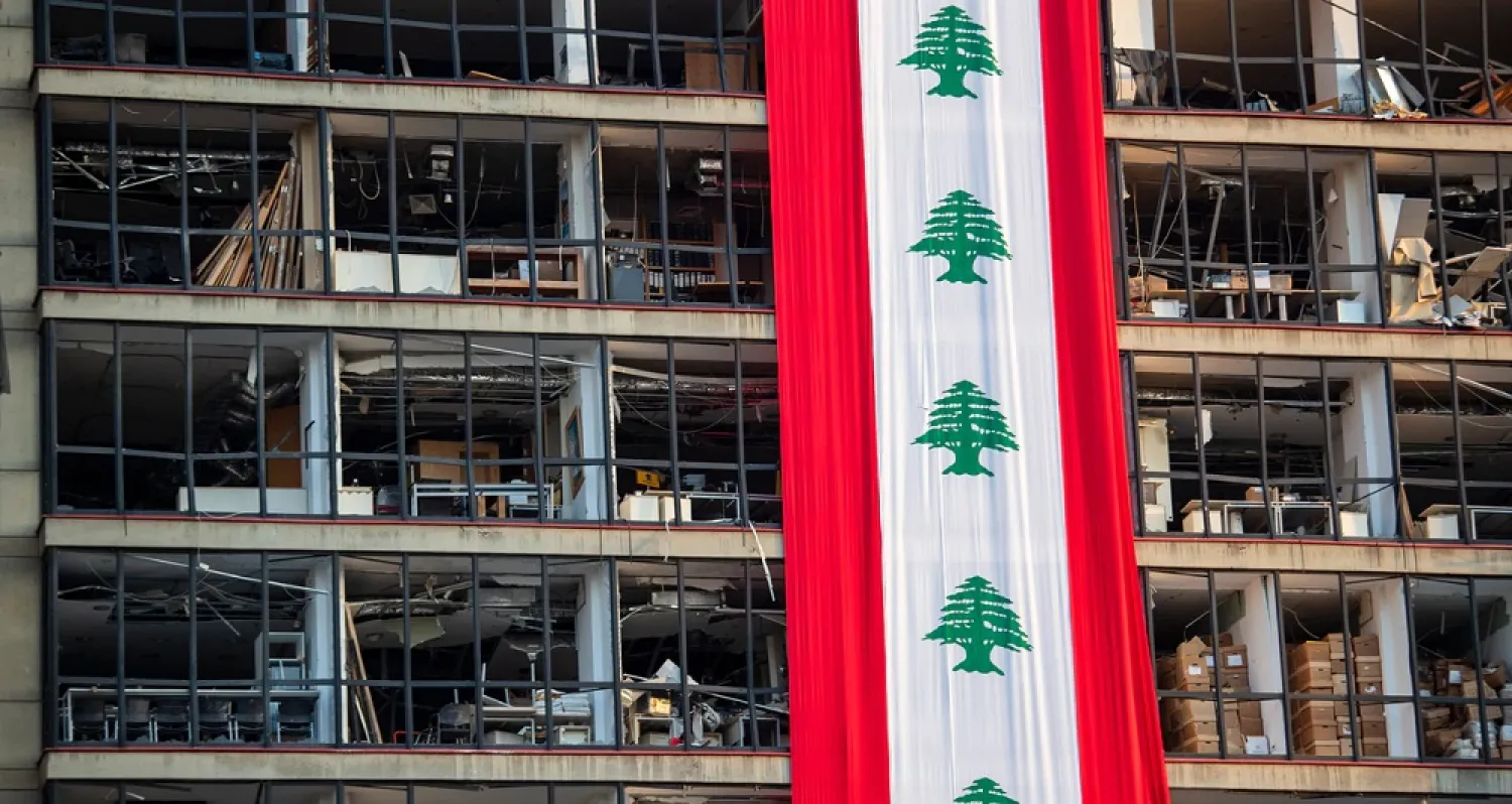 A banner with representations of the Lebanese flag hangs on a damaged building in a neighborhood near the site of the explosion that rocked the port of Beirut, Lebanon, Aug. 12, 2020. (AP)