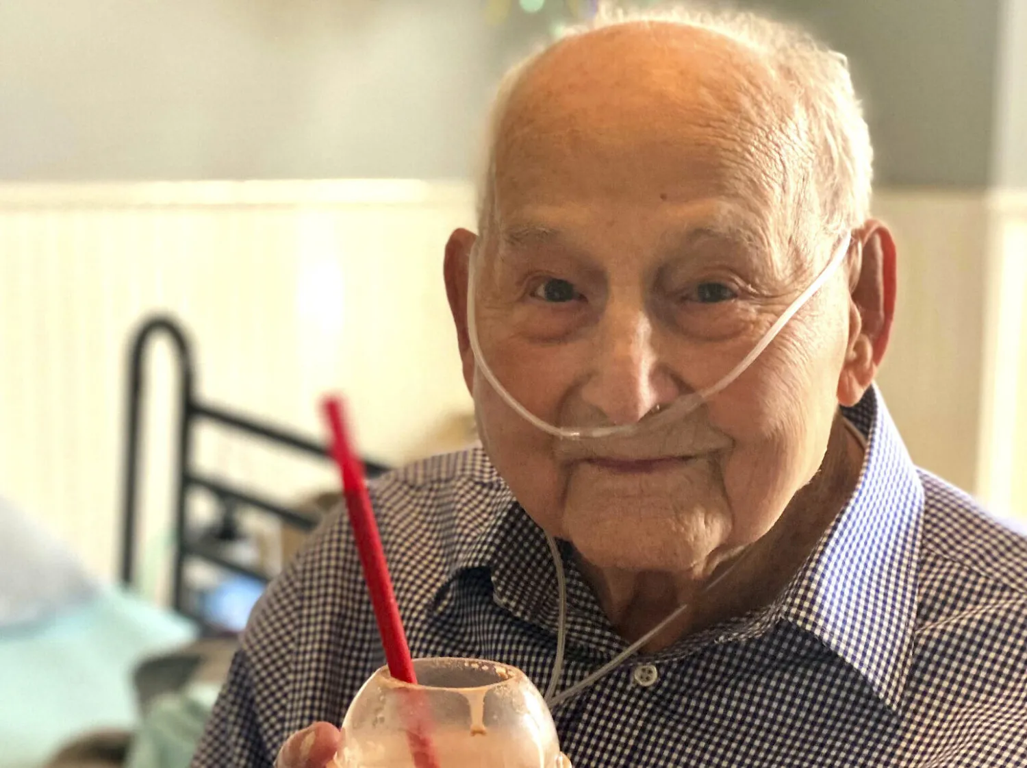 In this photo provided by Holly Wooten McDonald, World War II veteran and COVID-19 survivor Major Wooten holds a celebratory milkshake on his 104th birthday on Thursday, Dec. 3, 2020, in Madison, Alabama. Wooten was released from the hospital this week after contracting the illness caused by the new coronavirus before Thanksgiving. (Holly Wooten McDonald via AP)