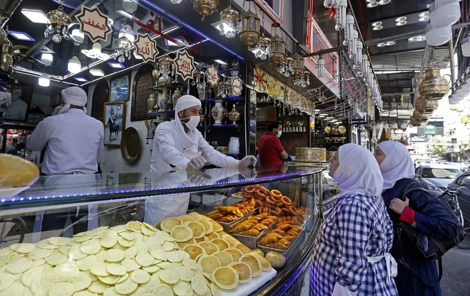 Syrians buy sweets for iftar during the Muslim holy month of Ramadan, at the Maidan market in Damascus on April 26, 2020. (AFP)