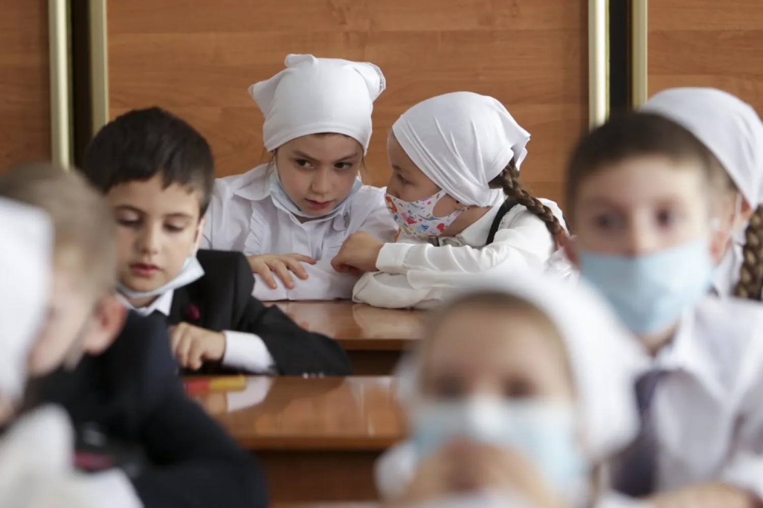Pupils wearing face masks to protect against coronavirus sit in a classroom during a ceremony marking the start of classes at a school - (AP Photo/Musa Sadulayev)
