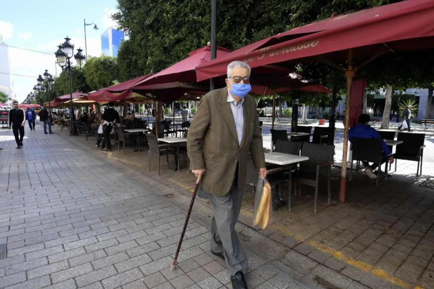 رجل مسن يرتدي كمامة في شارع الحبيب بورقيبة في تونس العاصمة (أ.ف.ب)