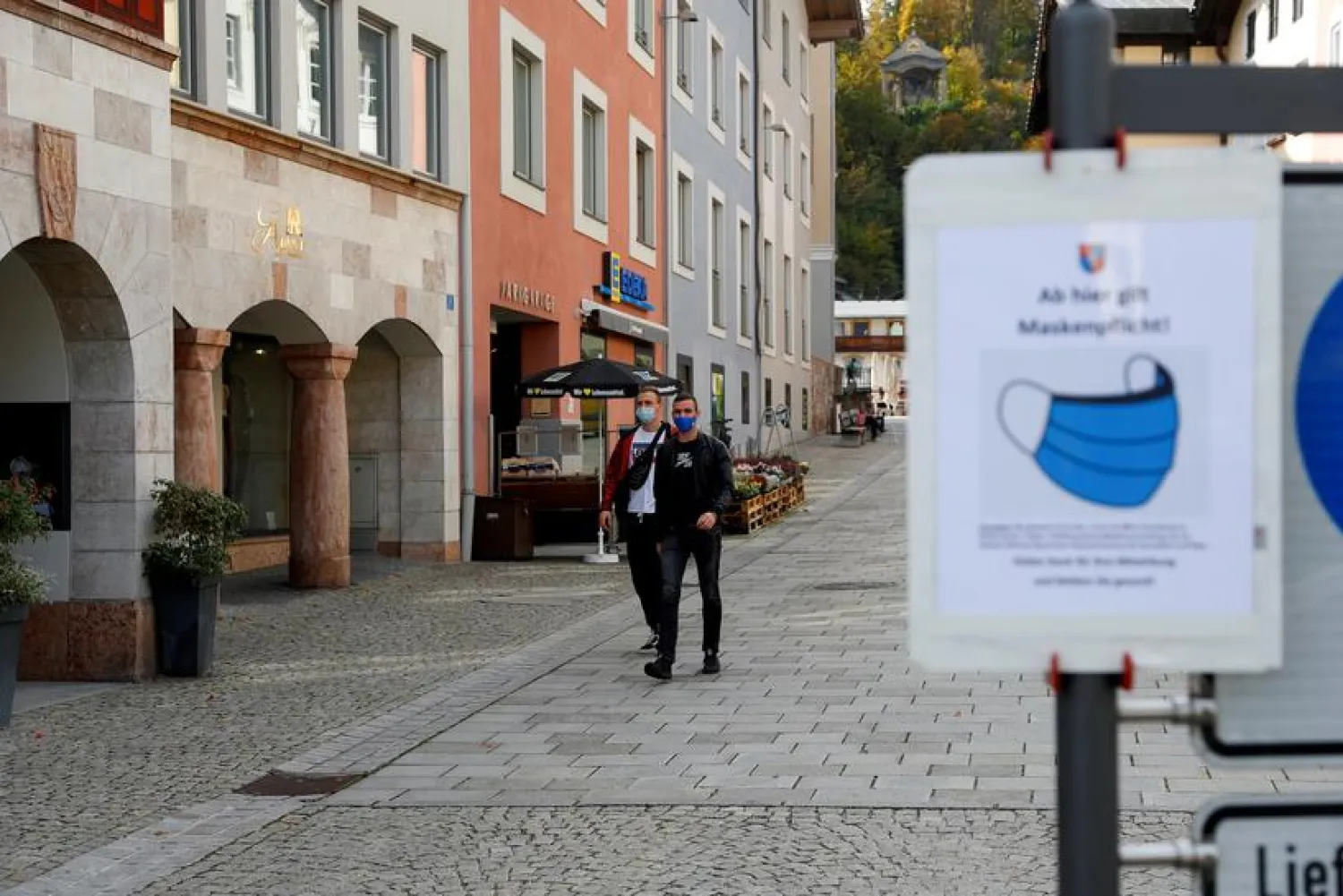 Men wearing protective face masks walk after residents of the Berchtesgadener Land district of Bavaria will not be able to leave their homes from October 20, 2020, without a valid reason for two weeks, making it the first area in Germany to go back into lockdown since April, in the city of Berchtesgaden, Germany October 20, 2020. REUTERS/Leonhard Foeger/File Photo
