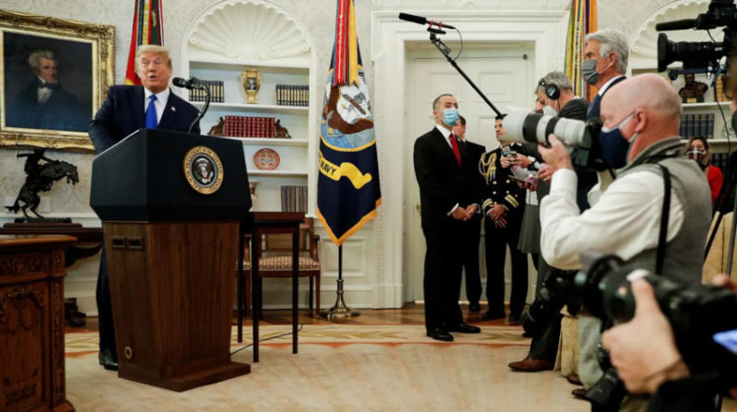 ترمب يتحدث قبل منحه «وسام الحرية» لبطل المصارعة دان غابل في المكتب البيضاوي أمس (رويترز)