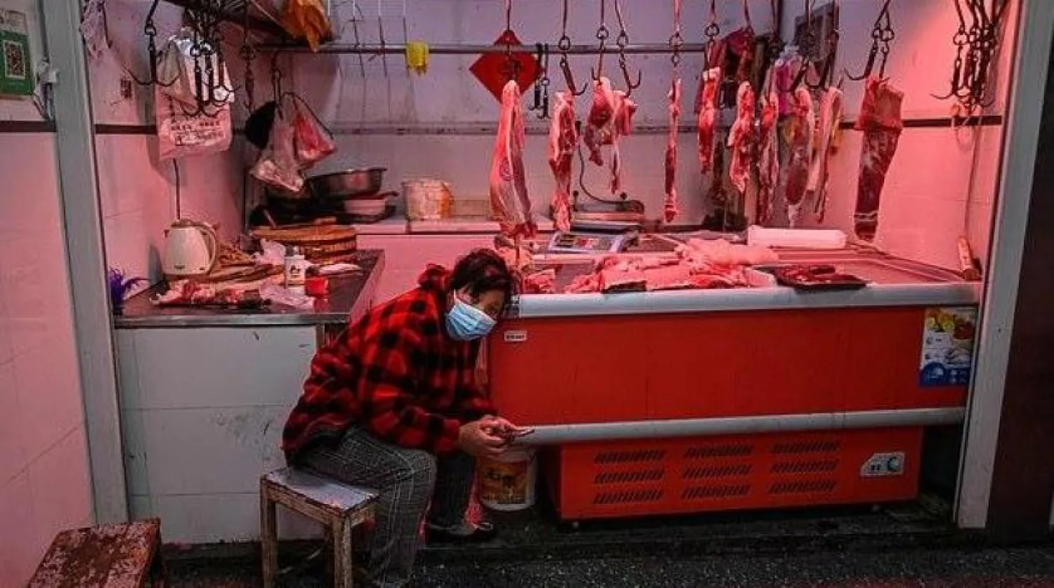 Wuhan’daki bir et dükkanında oturan satıcı (AFP)