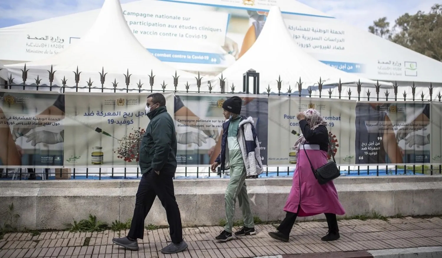 People walk past a bivouac where clinical trials for COVID-19 vaccines are conducted, in Rabat, Morocco, Dec. 7, 2020. (AP)