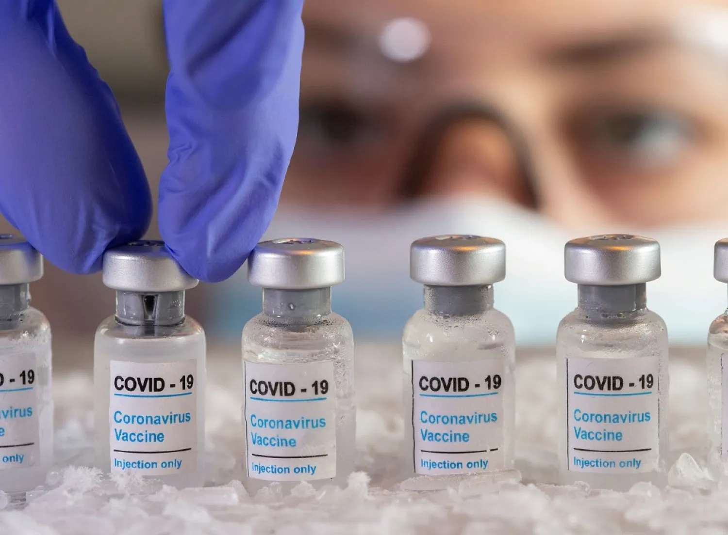A woman holds vials labelled ‘COVID-19 Coronavirus Vaccine’ over dry ice in this illustration taken, December 5, 2020. (Reuters)