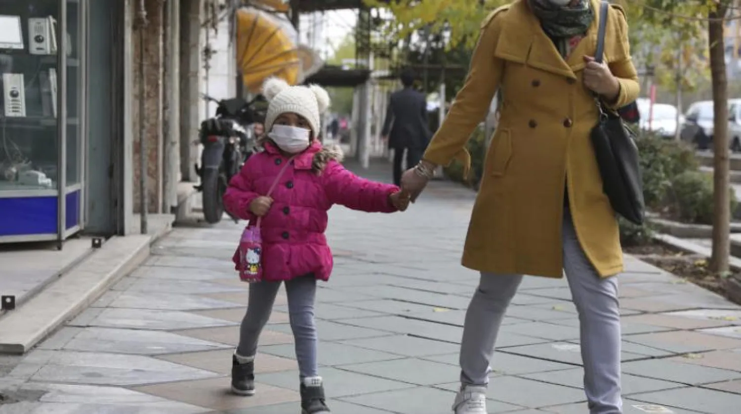 Tahran’da maskeleriyle dolaşan anne ve kız (AP)
