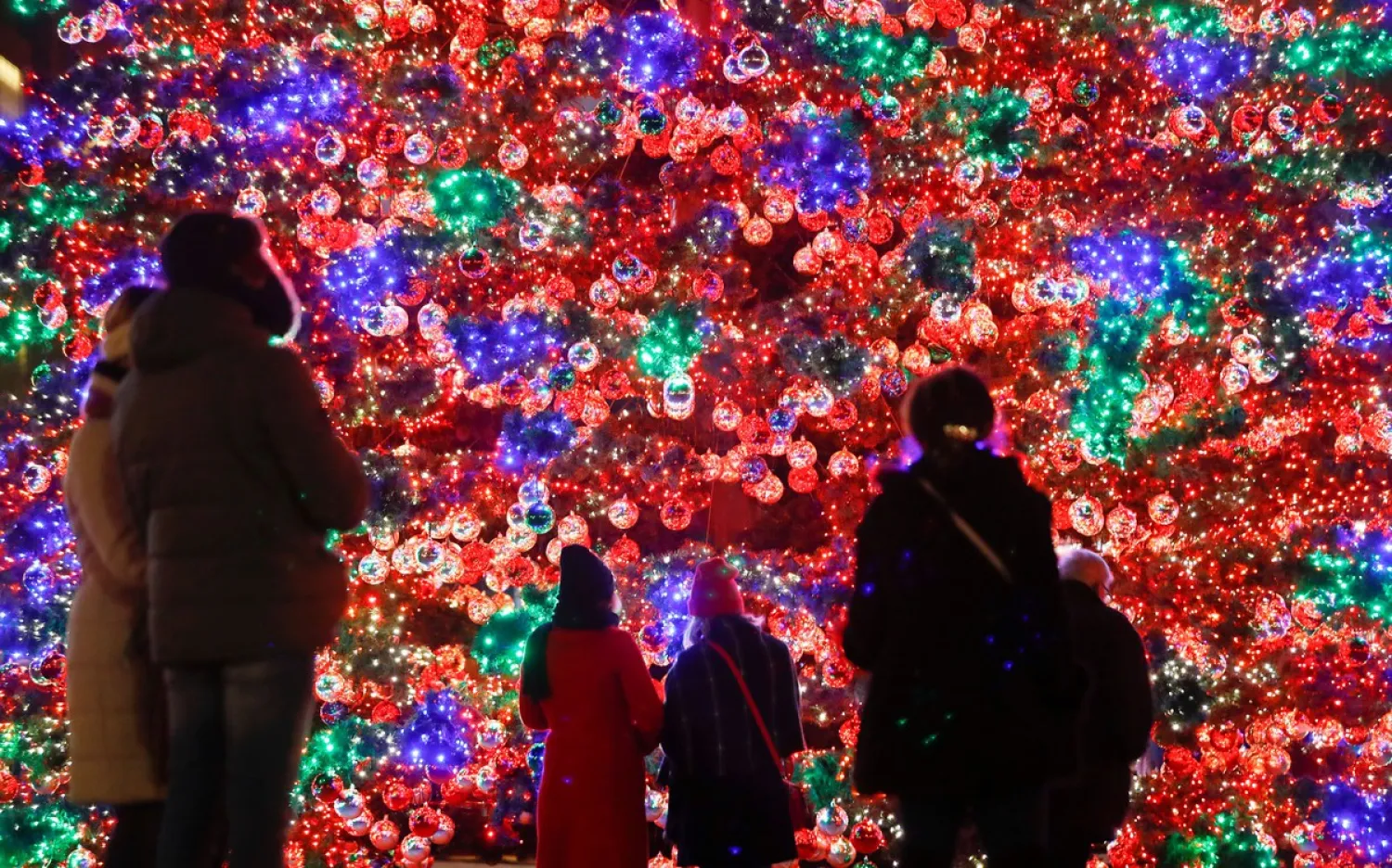 People gaze at an illuminated Christmas tree at Marlene-Dietrich-Platz square in Berlin, Germany, on December 1, 2019. Fabrizio Bensch / Reuters
