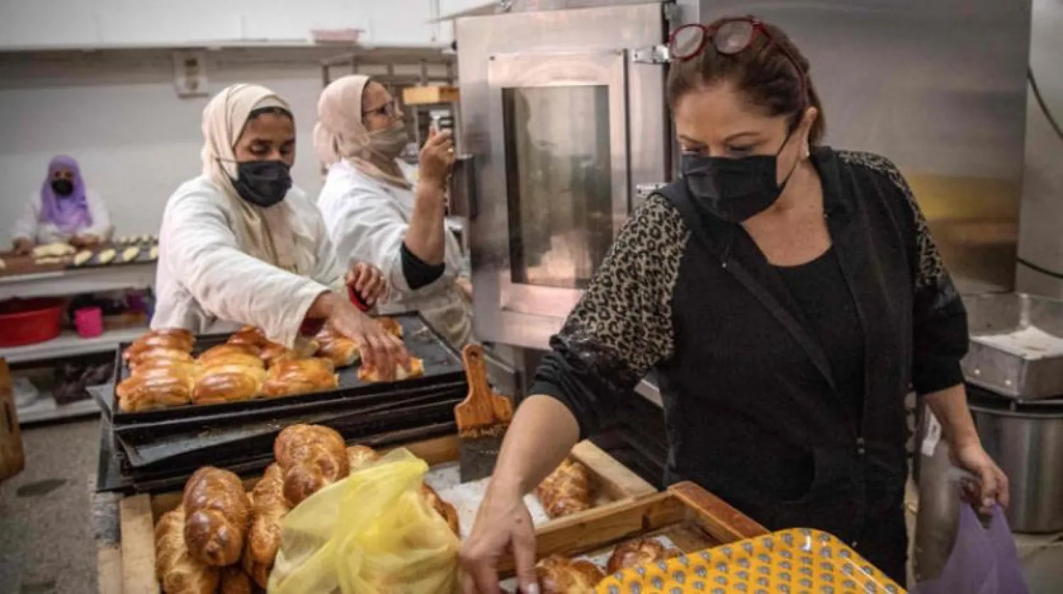 A Moroccan Jewish woman (R) fills bags with pastries at a kosher bakery in the western Moroccan port city of Casablanca, on December 11, 2020. (Photo by FADEL SENNA / AFP)