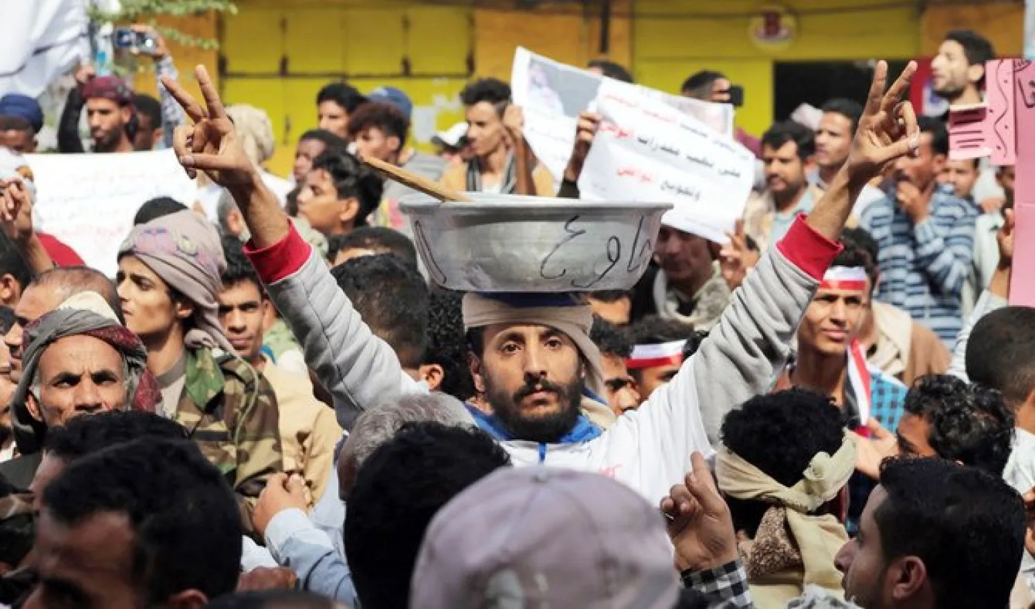 Yemenis march with banners during a demonstration against the deteriorating economic situation in Taiz. (File/AFP)
