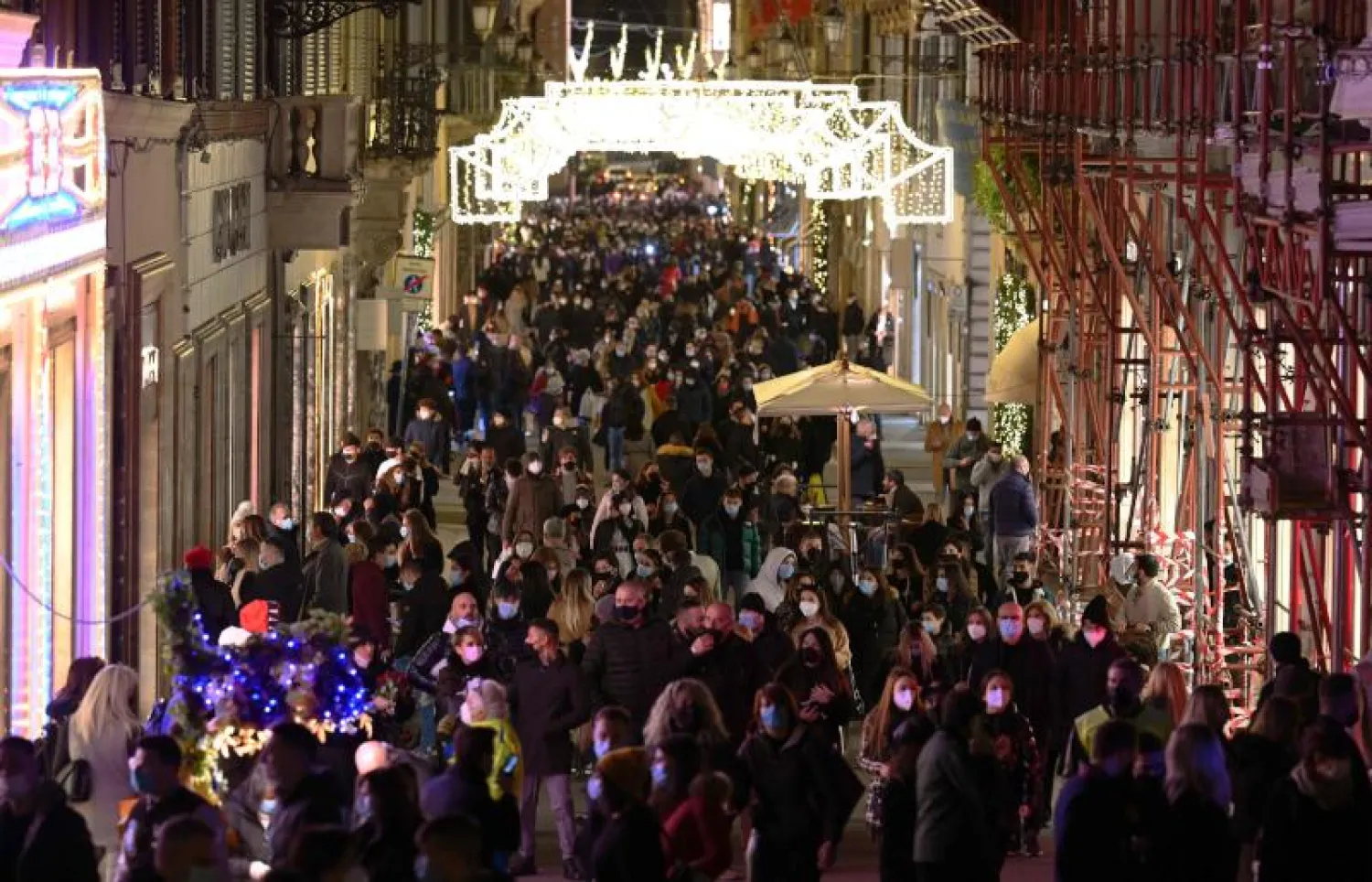 أشخاص يتجولون وسط روما للتسوق استعداداً لأعياد الميلاد (أ.ف.ب)