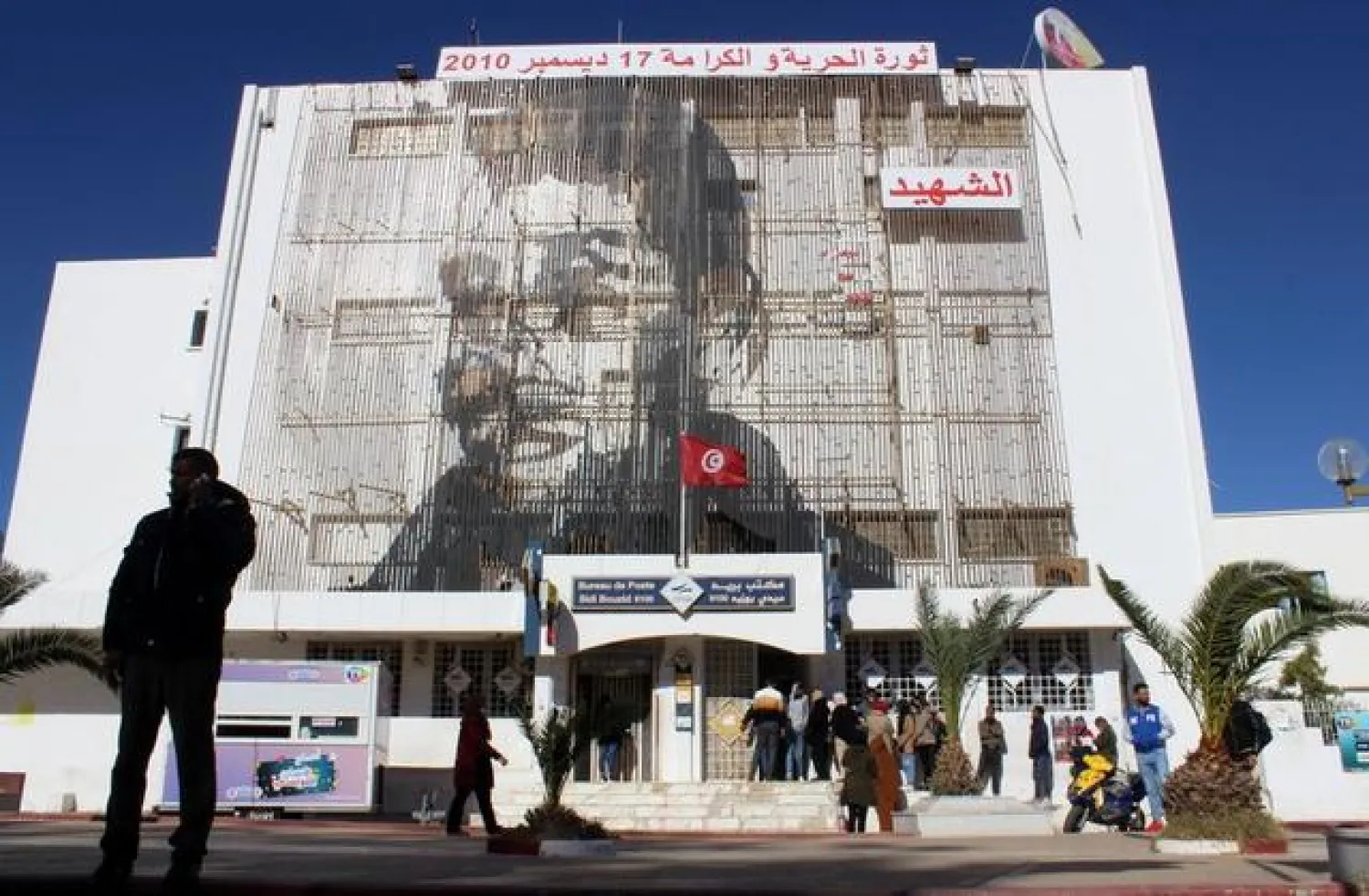 A picture of Mohamed Bouaziz, a street vendor who set himself alight 10 years ago on December, 17, 2010, is displayed on the post office building in Sidi Bouzid, Tunisia December 8, 2020. | Photo: REUTERS