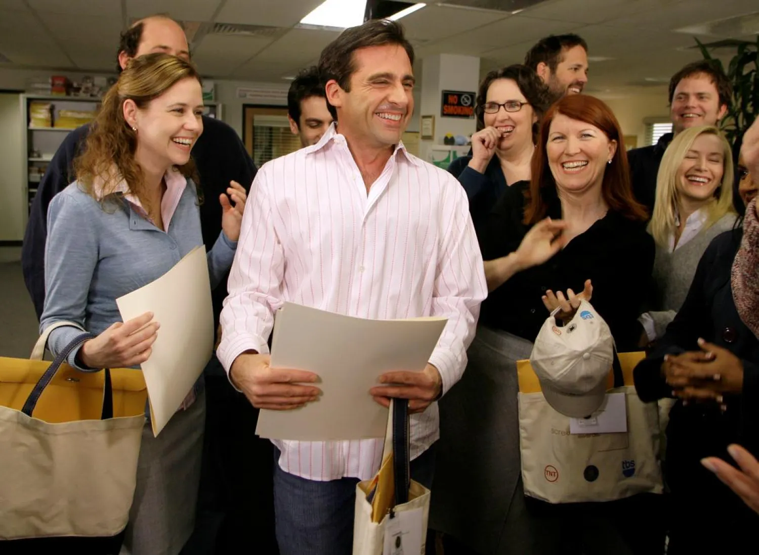 FILE PHOTO: Actor Steve Carell (C) laughs along with other members of "The Office" cast including Jenna Fischer (L), Phyllis Smith, (2rd R, in glasses) and Kate Flannery (2nd R) as he receives certificates for his three Screen Actors Guild Awards nominations for outstanding performance by a male actor in a comedy series in "The Office," outstanding performance by an ensemble in a comedy series in "The Office," and outstanding performance by the cast of a motion picture in "Little Miss Sunshine," on the set of the television show "The Office," in Panorama City, California, January 11, 2007. REUTERS/Danny Moloshok//File Photo