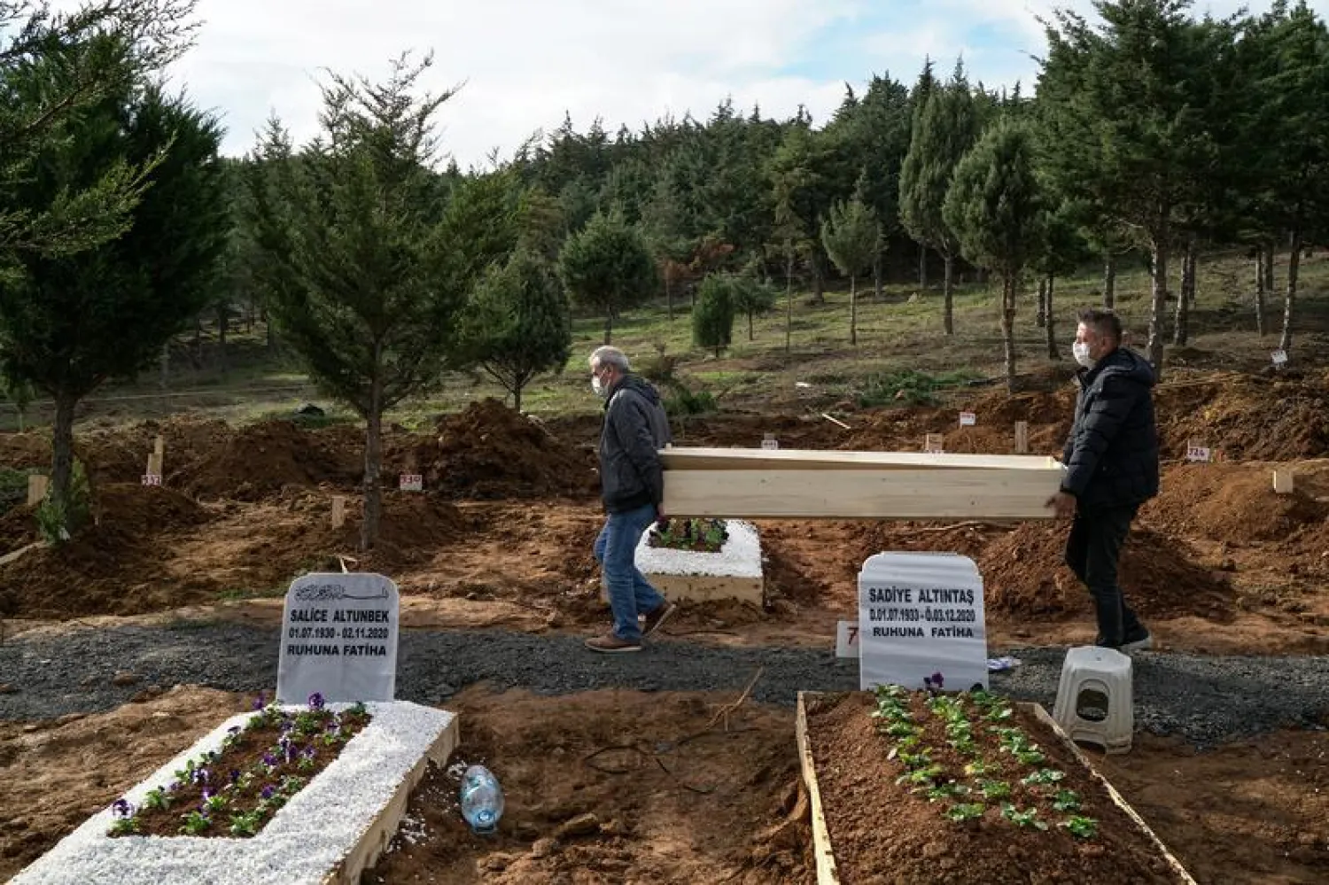 People carry an empty coffin of their relative, a victim of coronavirus disease (COVID-19), after his funeral ended at Kilyos cemetery in Istanbul, Turkey, December 10, 2020. Picture taken December 10, 2020. REUTERS/Umit Bektas
